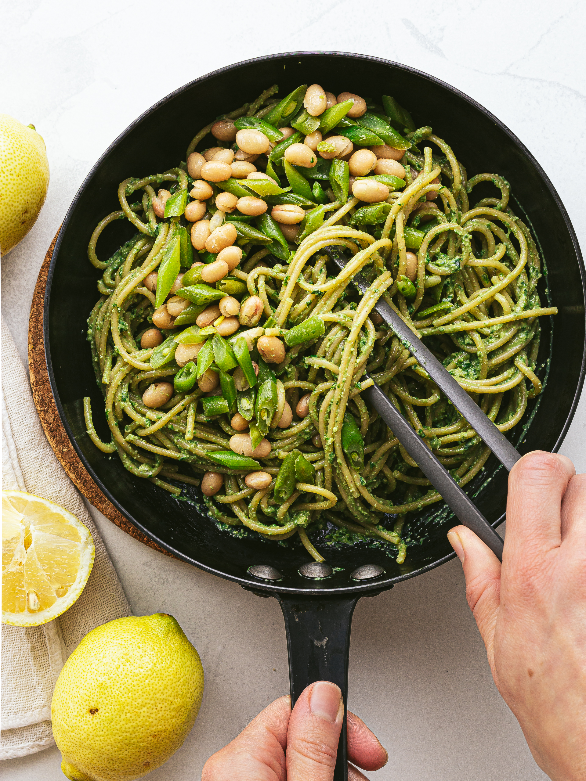 tofu pesto pasta with green beans and cannellini in a skillet