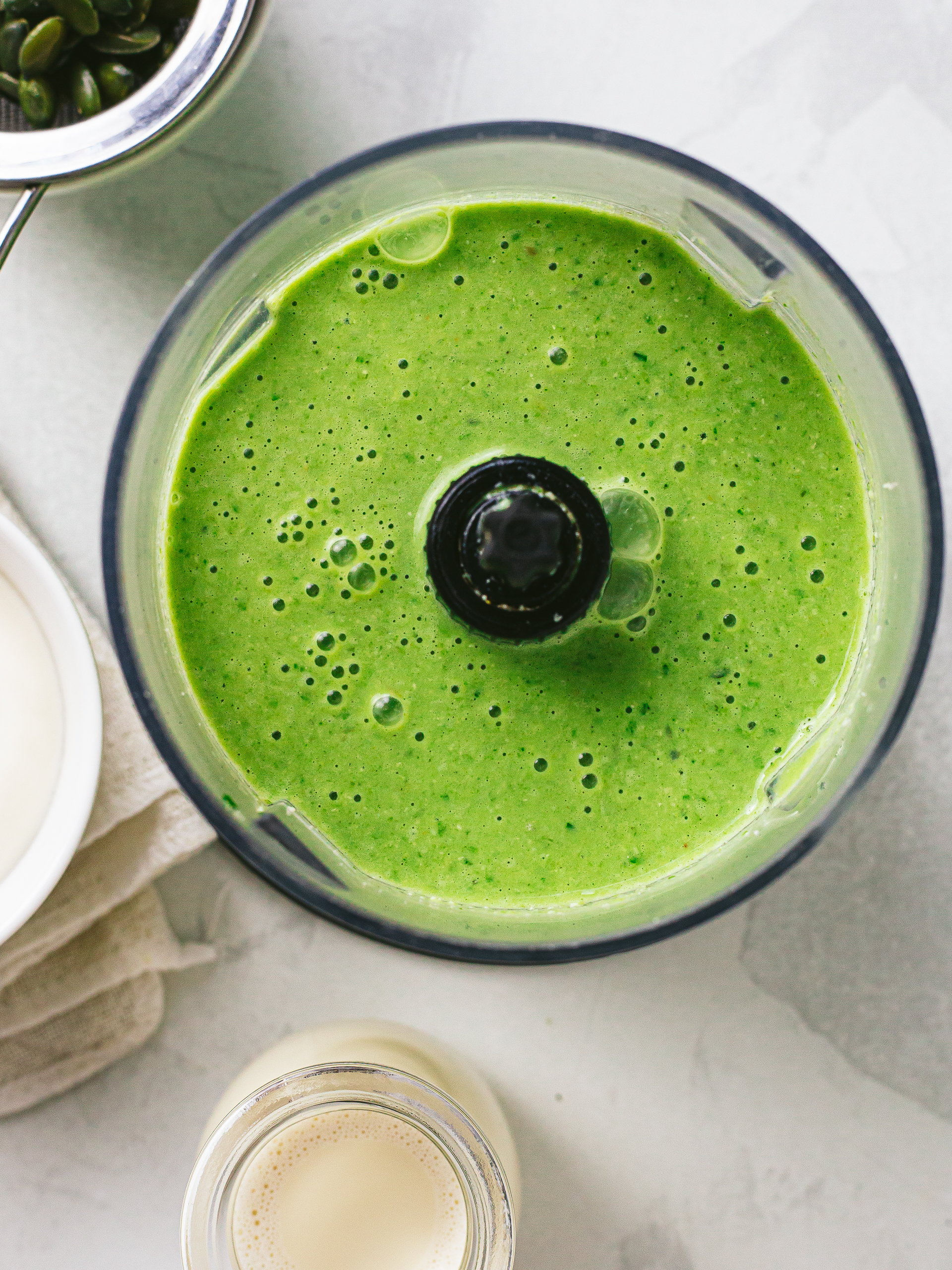 green smoothie with spinach pumpkin seeds and yoghurt in a blender