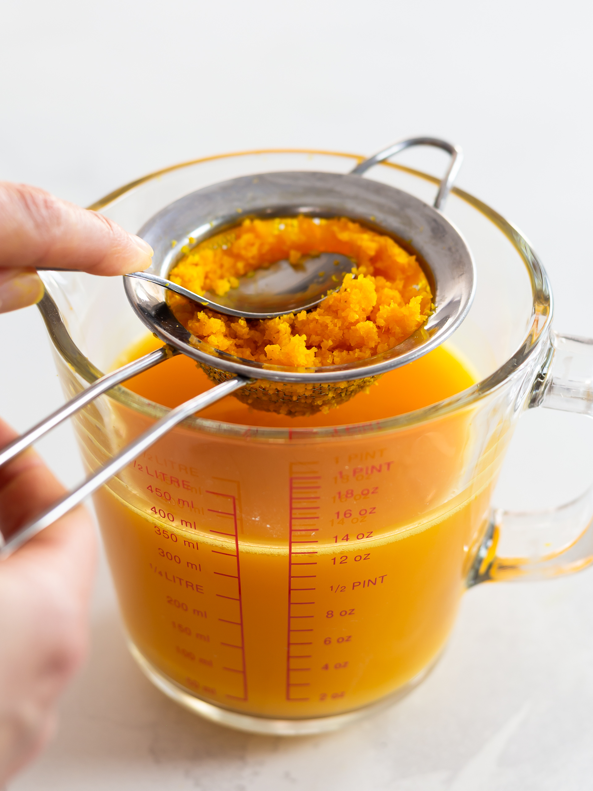 Ginger turmeric carrot juice filtered through a strainer