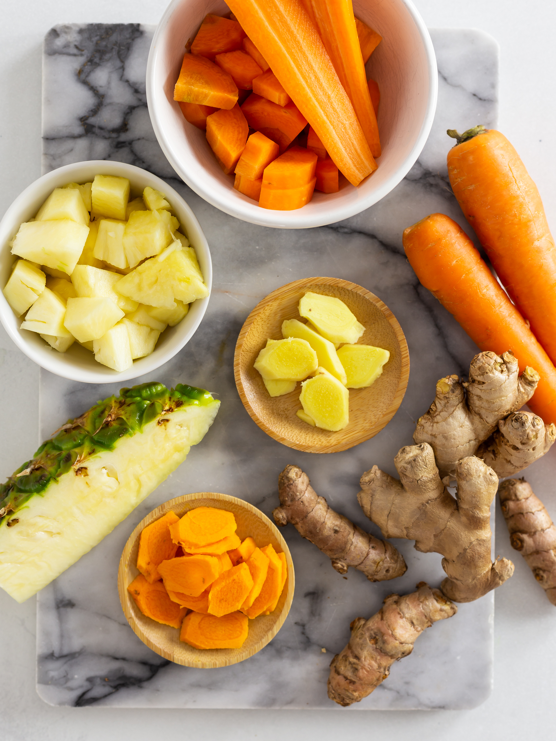 Peeled and chopped carrot, ginger, turmeric and pineapple