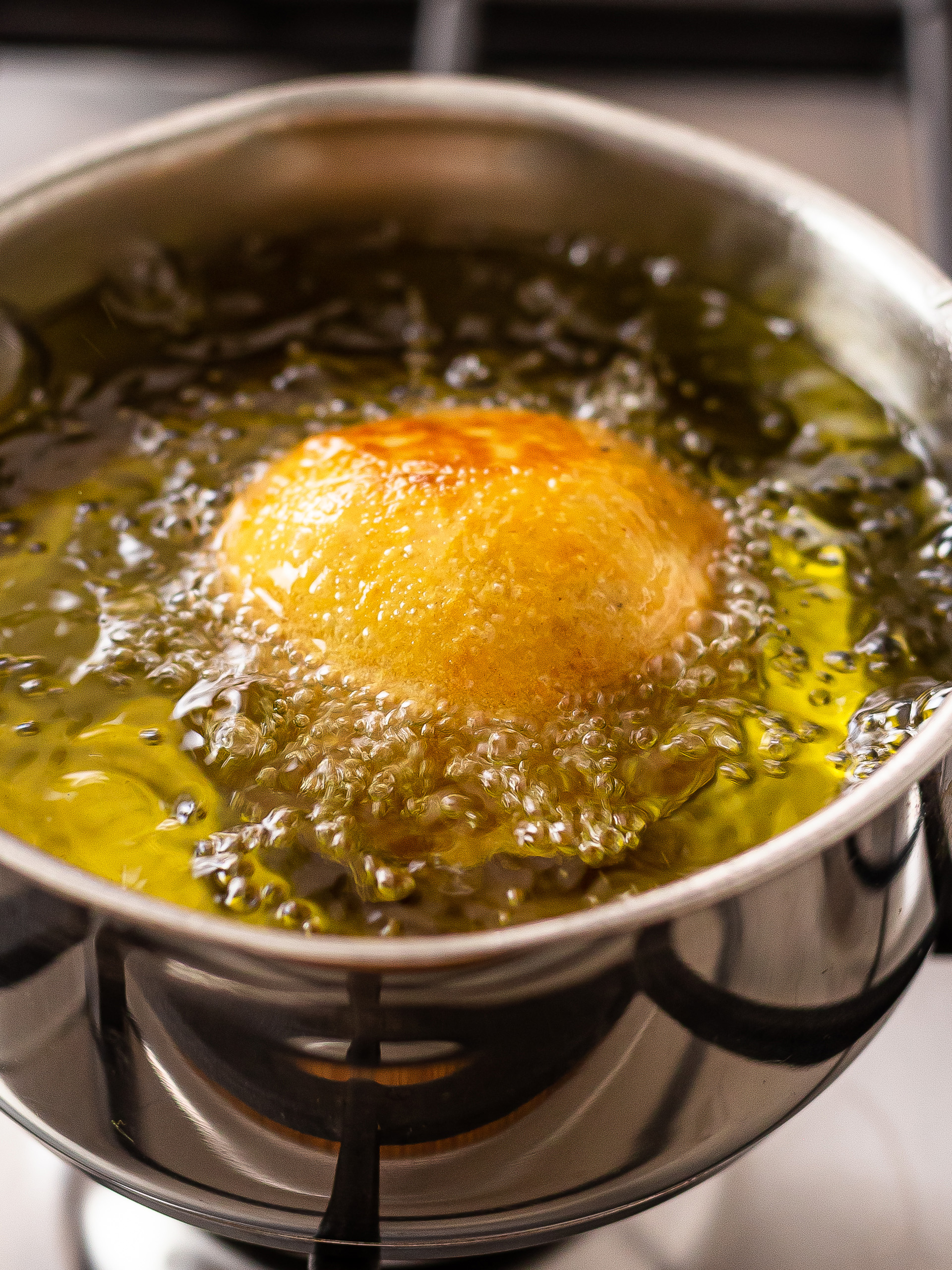 egg buns frying in oil in a pot