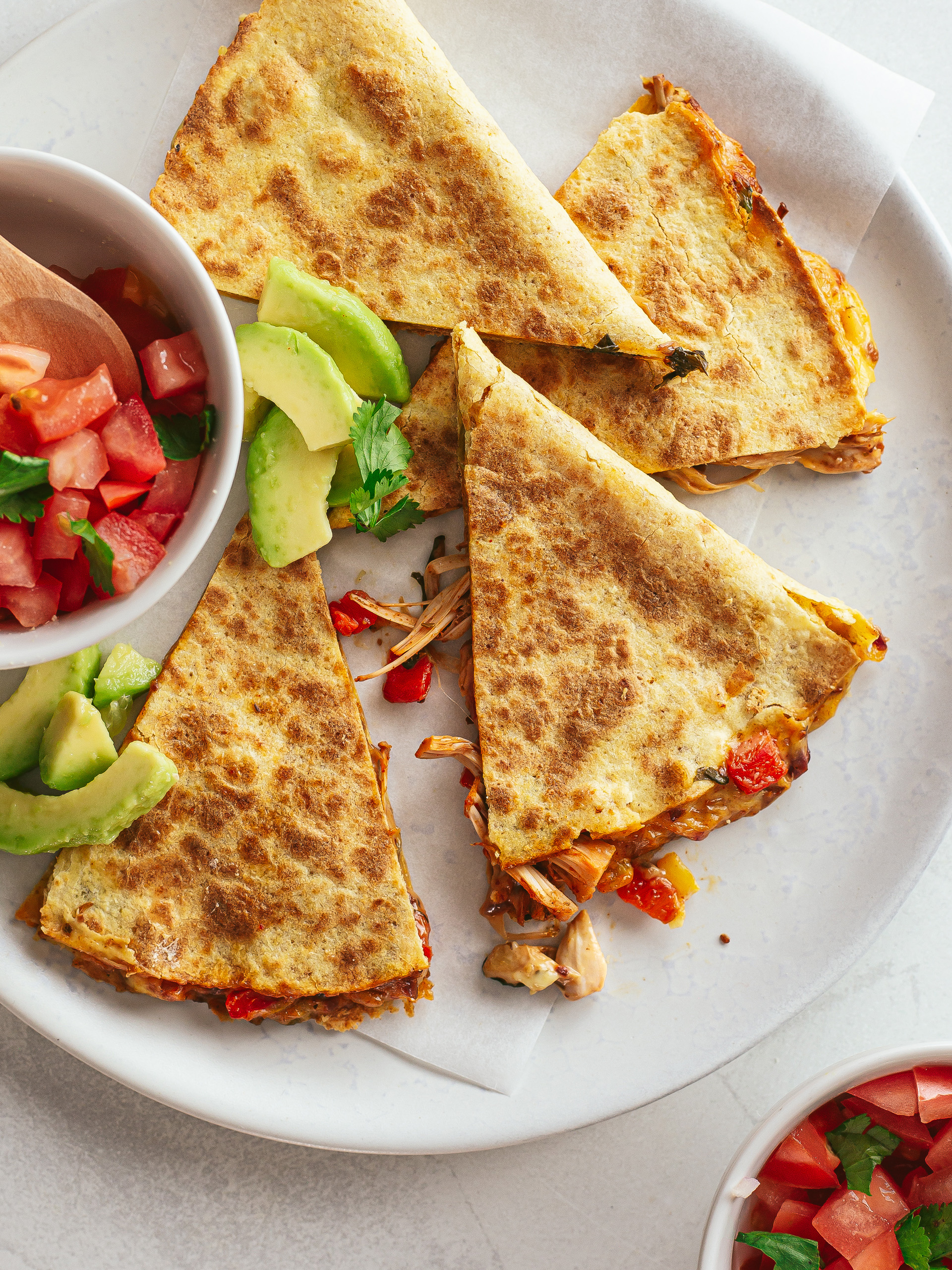 jackfruit quesadillas on a plate with tomatoes and avocados