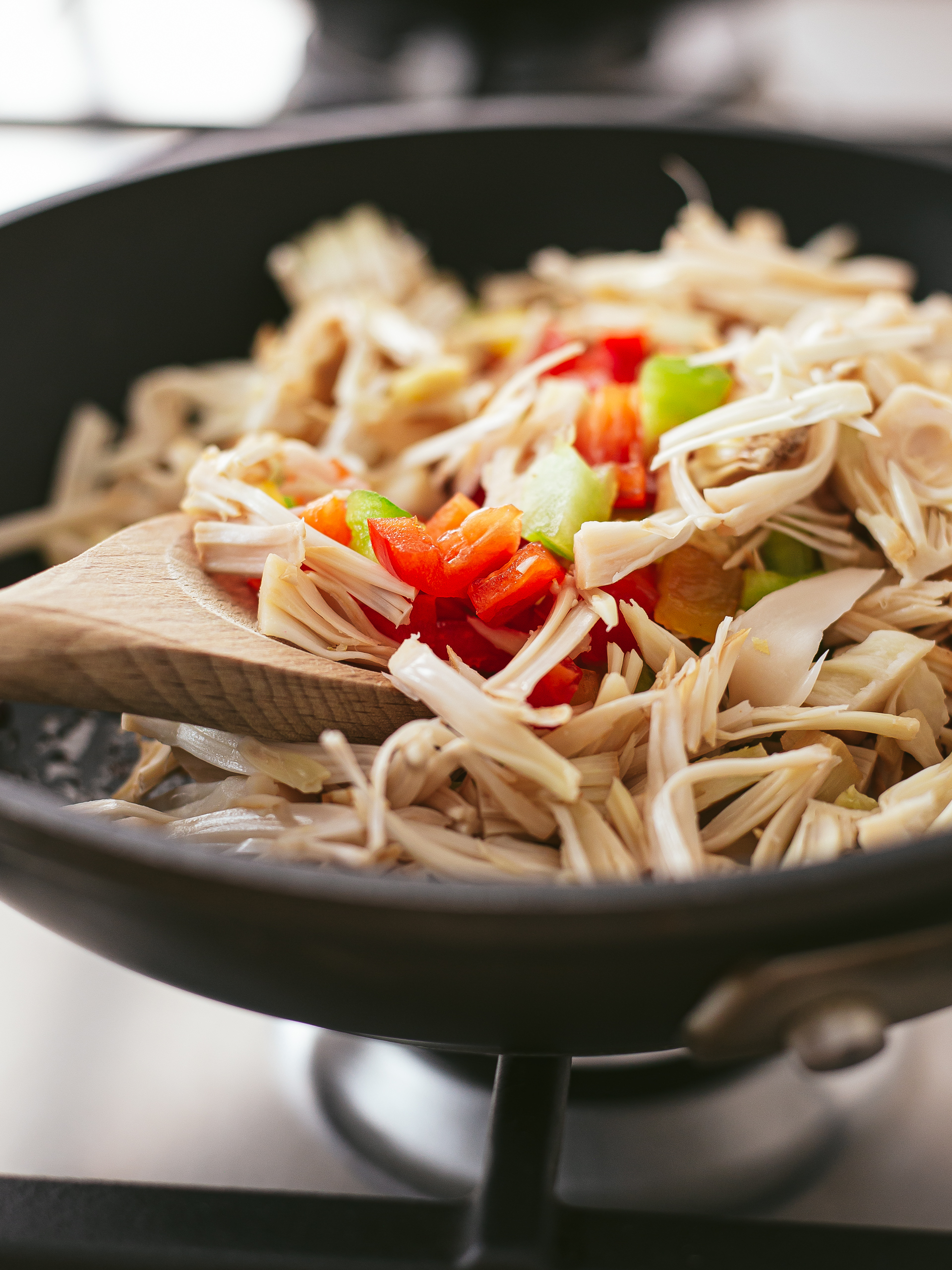 pulled young jackfruit in a pan with diced peppers