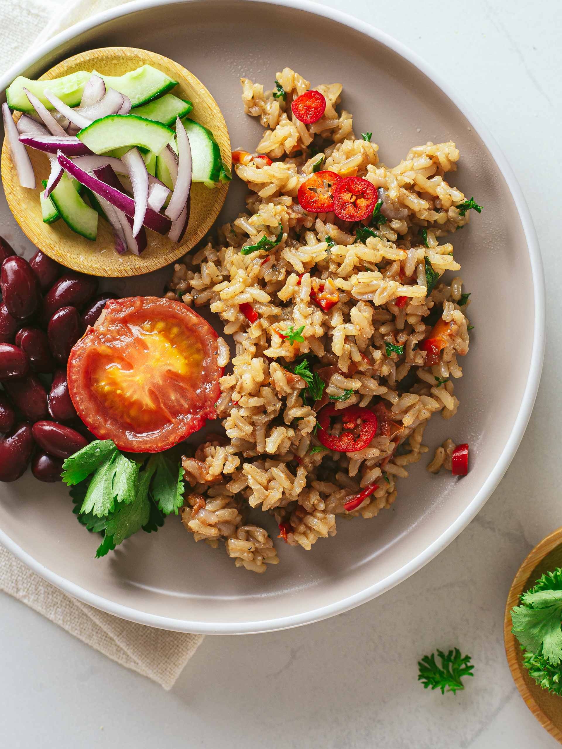 vegan kenyan pilau served with cucumber salad and beans