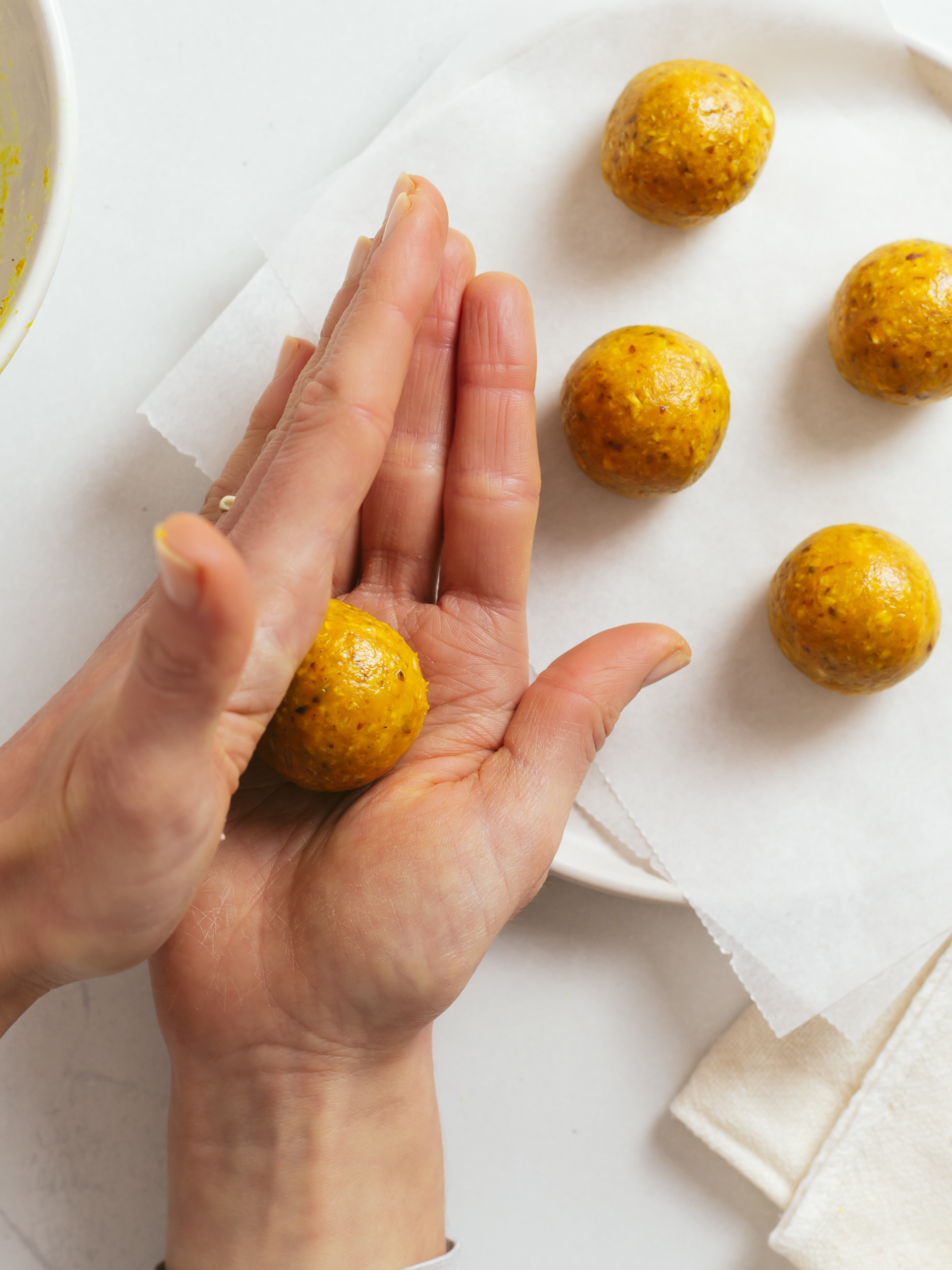 hands shaping oat dough into small balls