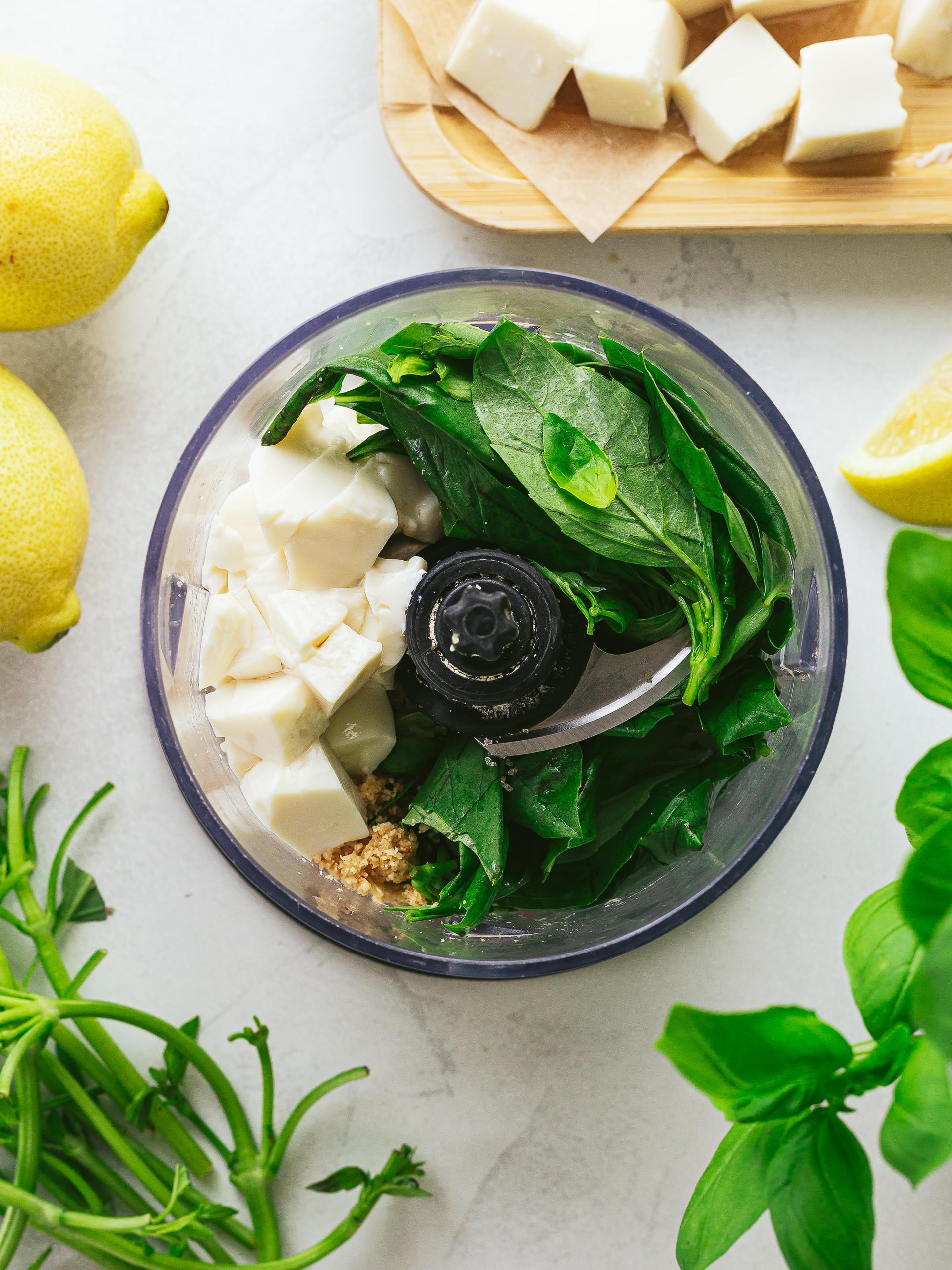 food processor with basil, silken tofu, lemon juice and cashews for pesto