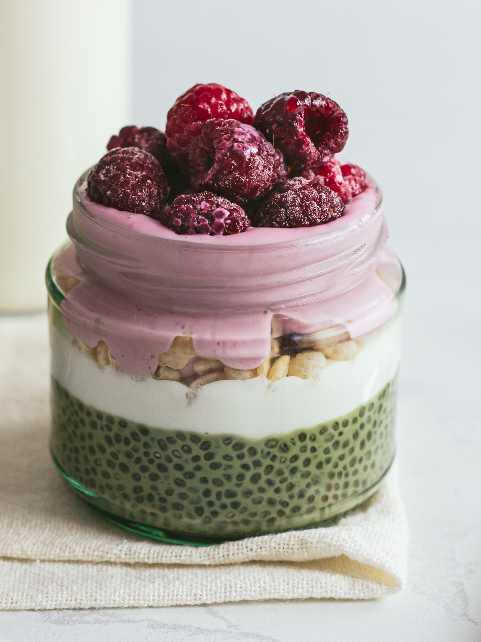 matcha chia pudding topped with yogurt, puffed rice, and raspberries