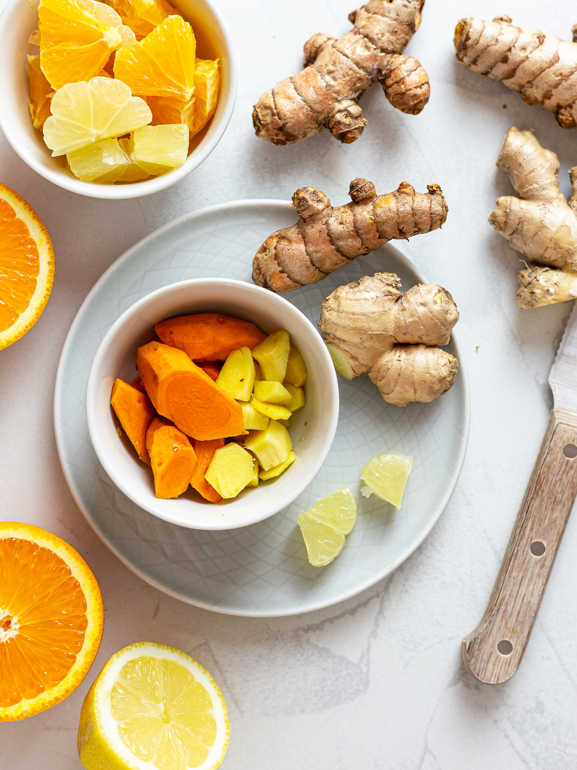 peeled and chopped ginger and turmeric root and oranges and lemons