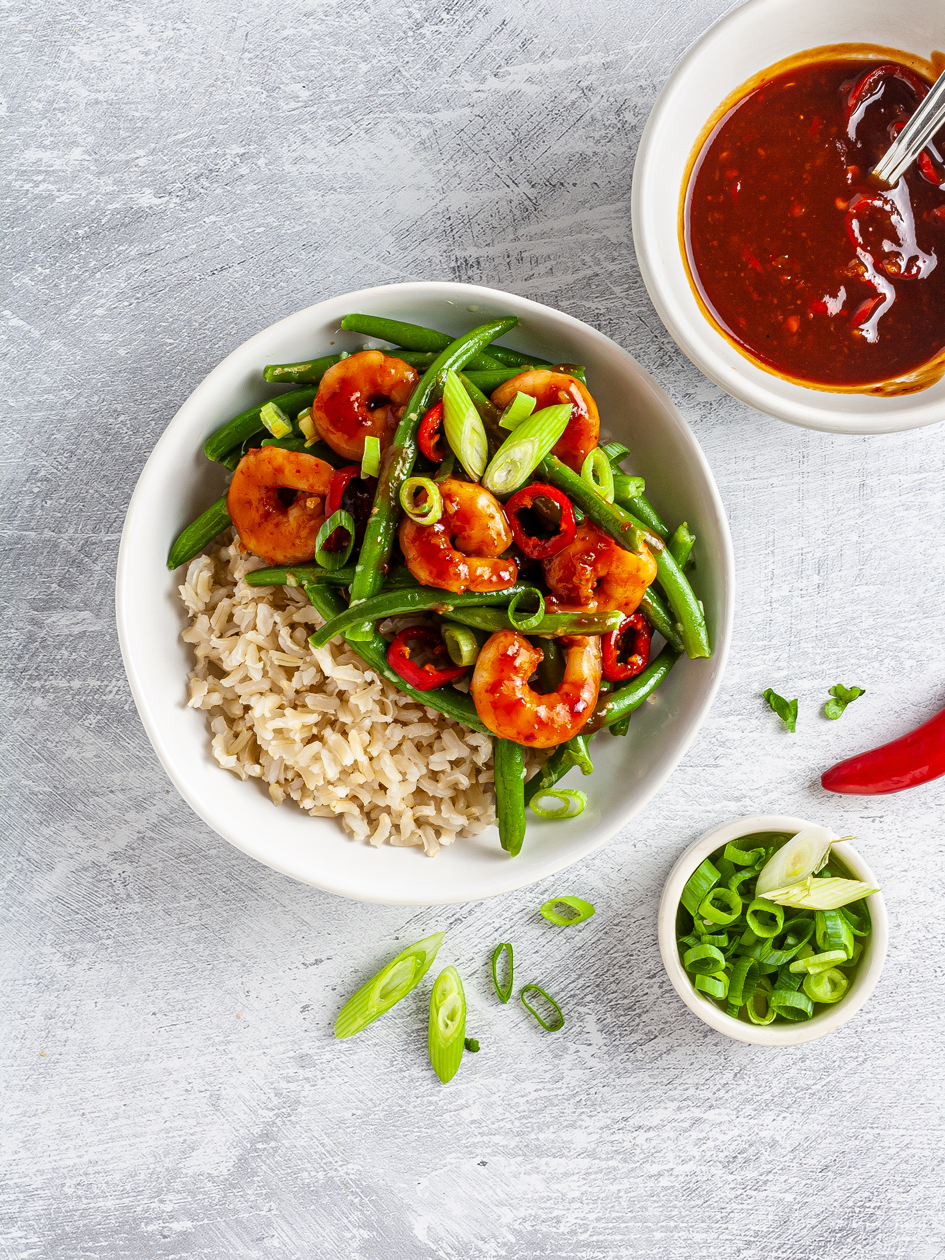 Sweet chili prawns bowl with brown rice, green beans, and spring onions