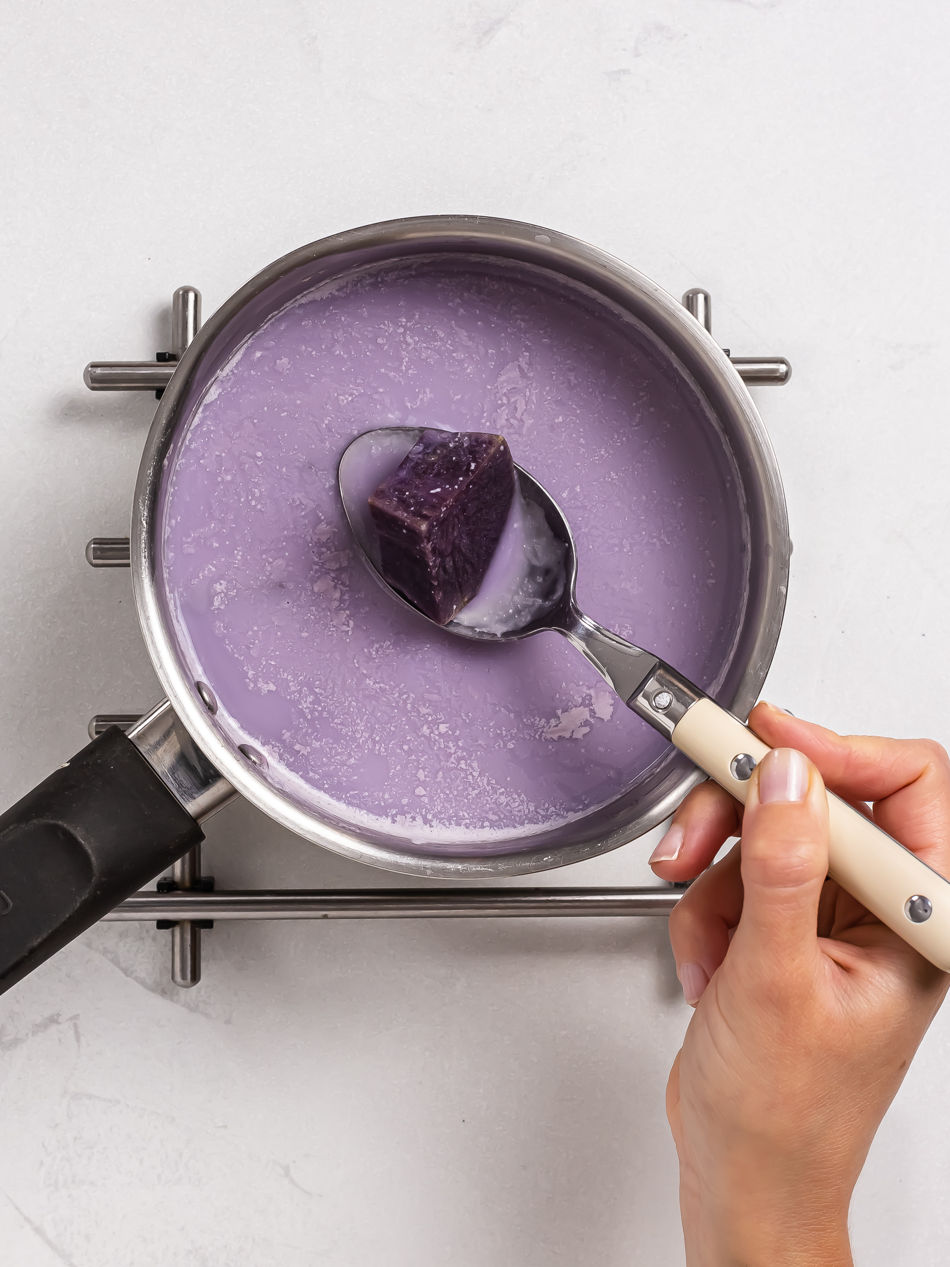 cooking ube with milk in a pot