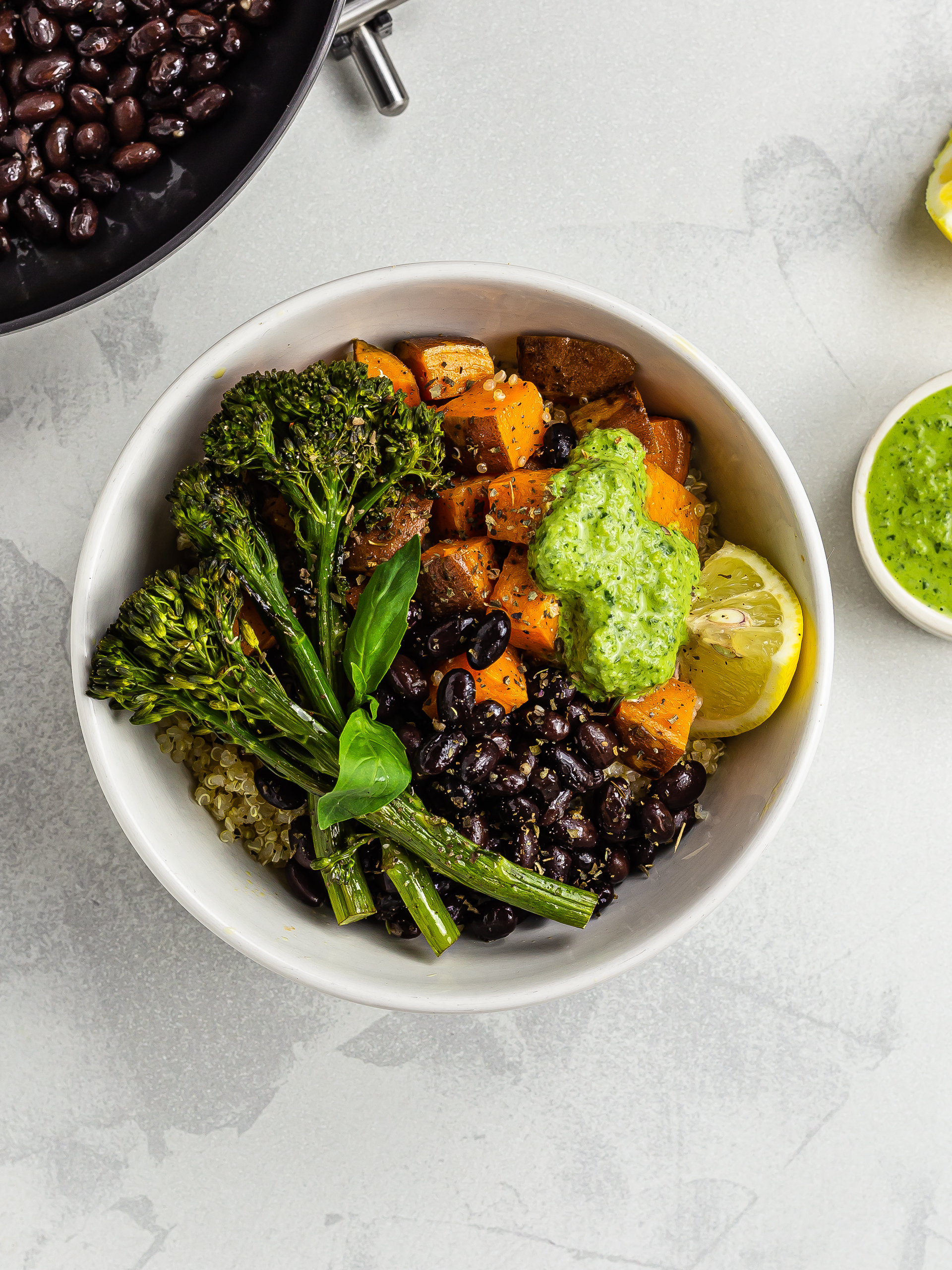 Sweet potato quinoa bowl with black beans and green tahini pesto