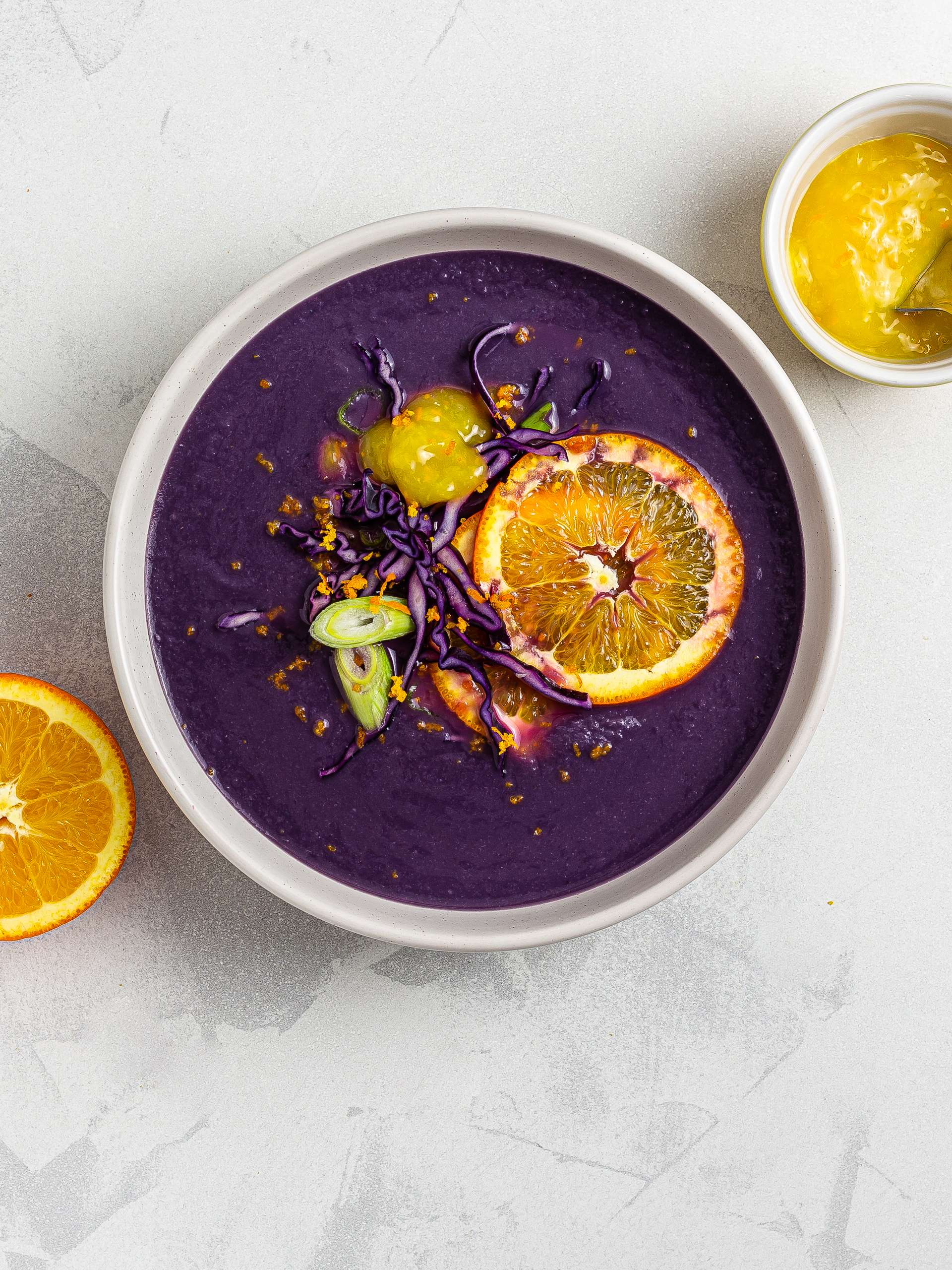 Red cabbage soup topped with orange sauce