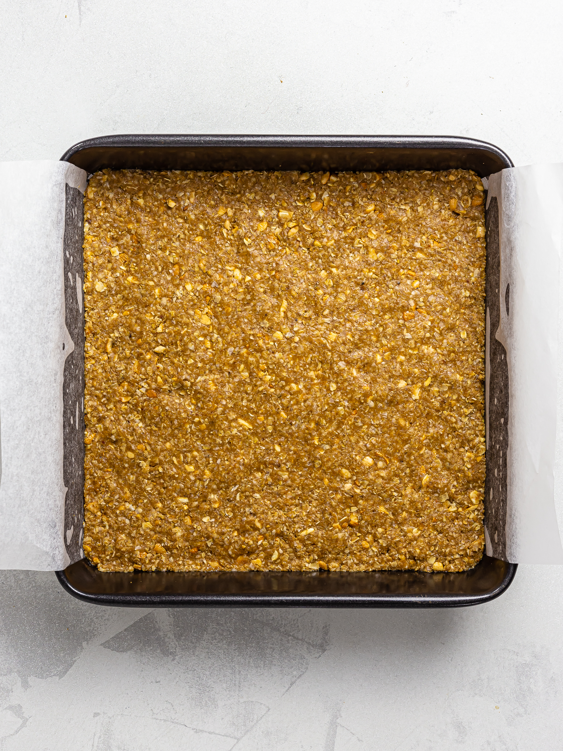 granola bar dough in a square tin