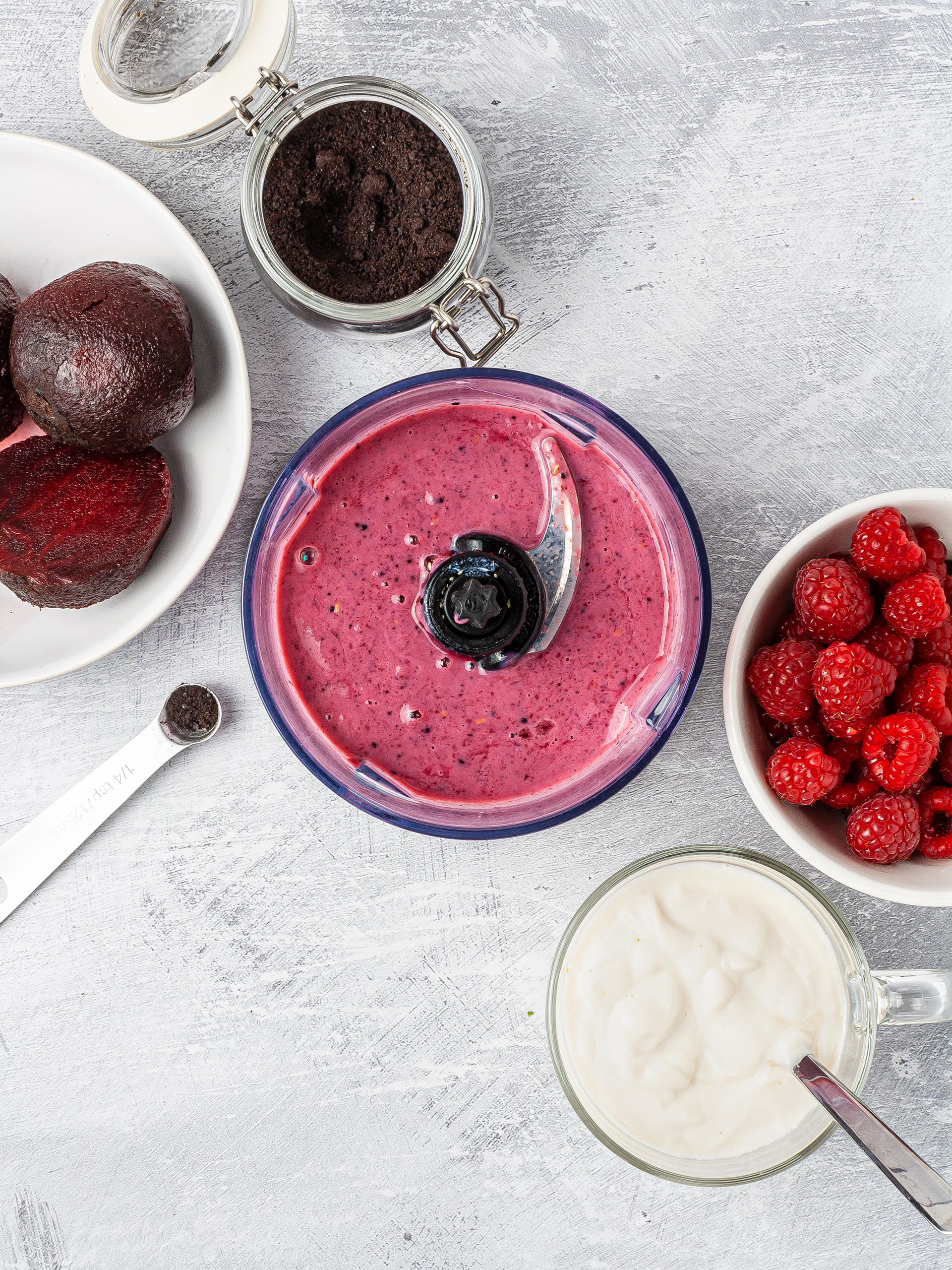 Raspberry smoothie blended with soy yogurt, beetroot, and acai berry powder in a food processor.