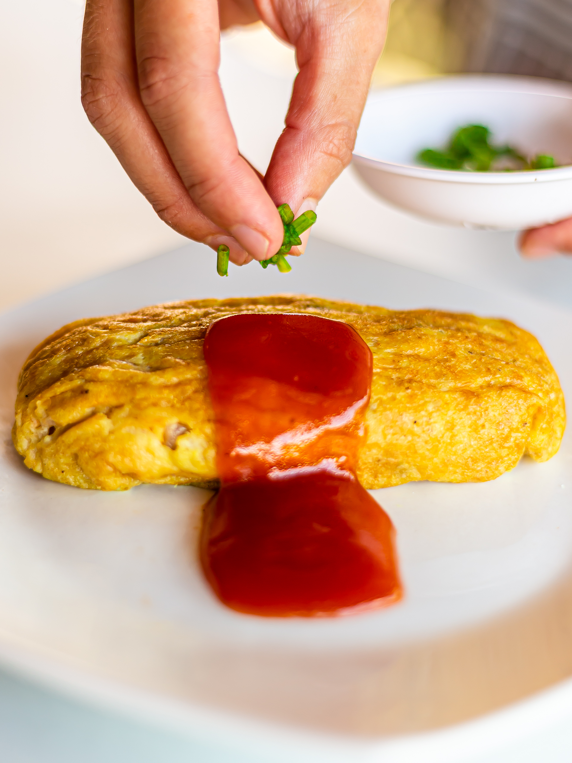 vegan omurice topped with ketchup and spring onions