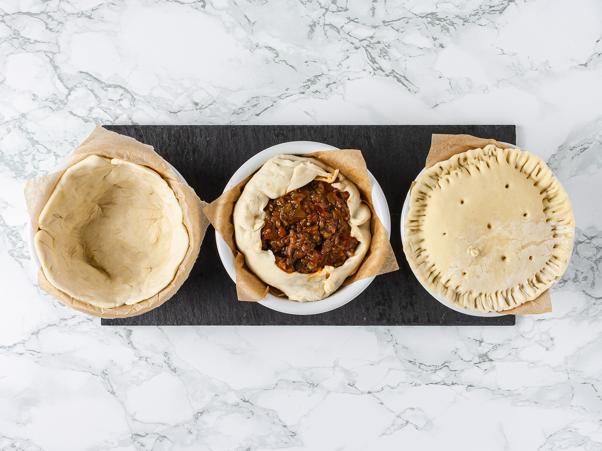 Puff pastry in ramekins shaped into mini minced lamb pies 