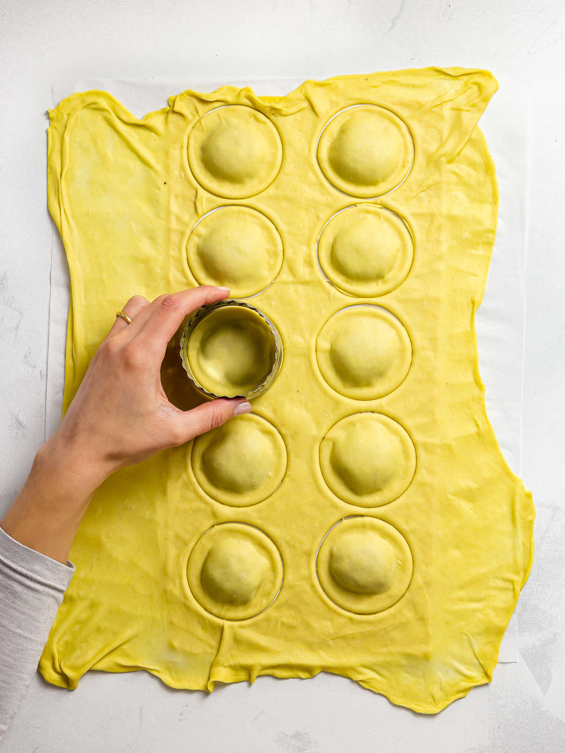 woman cutting ravioli discs with a cookie cutter