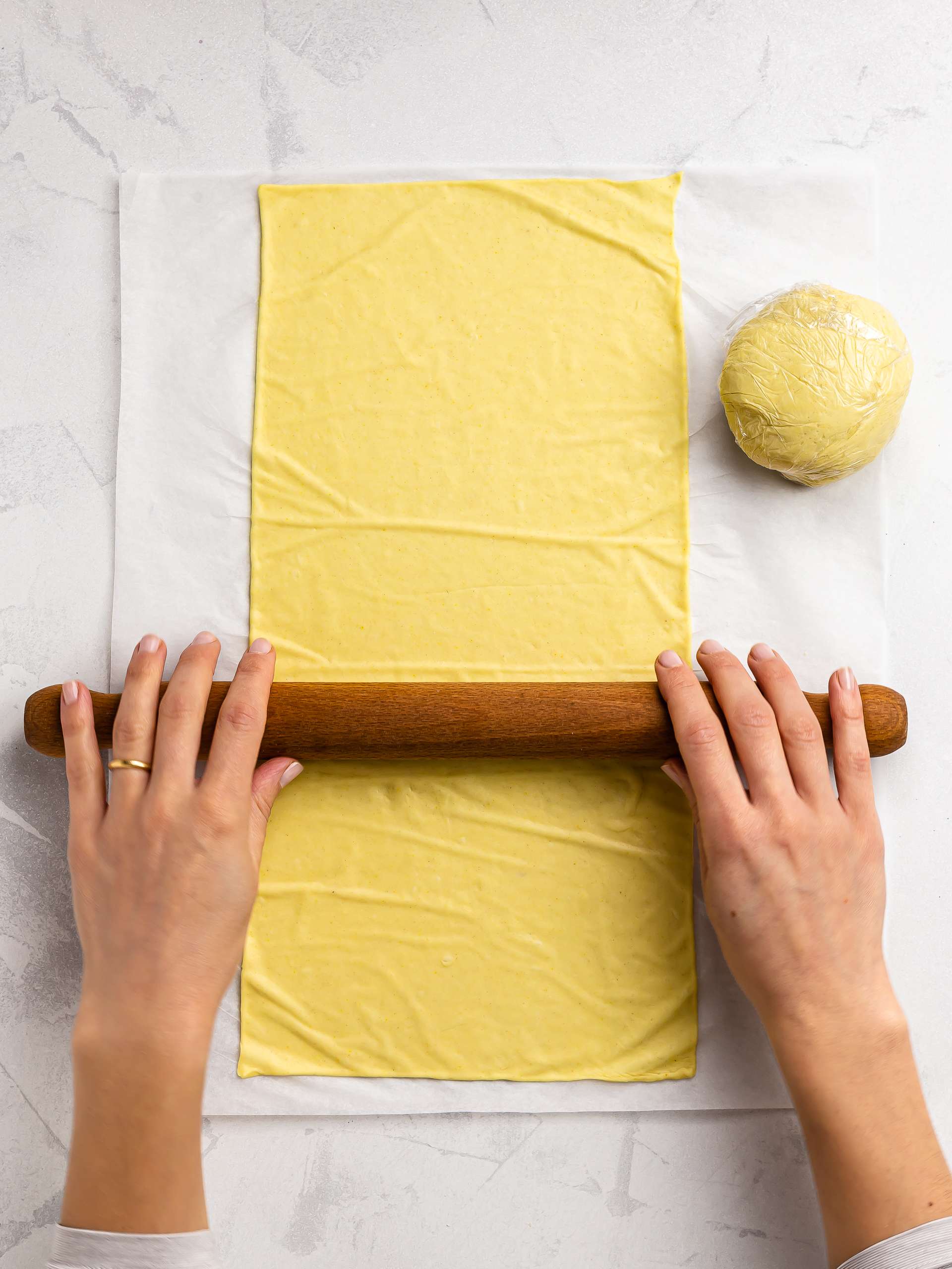 woman rolling out a sheet of pasta dough