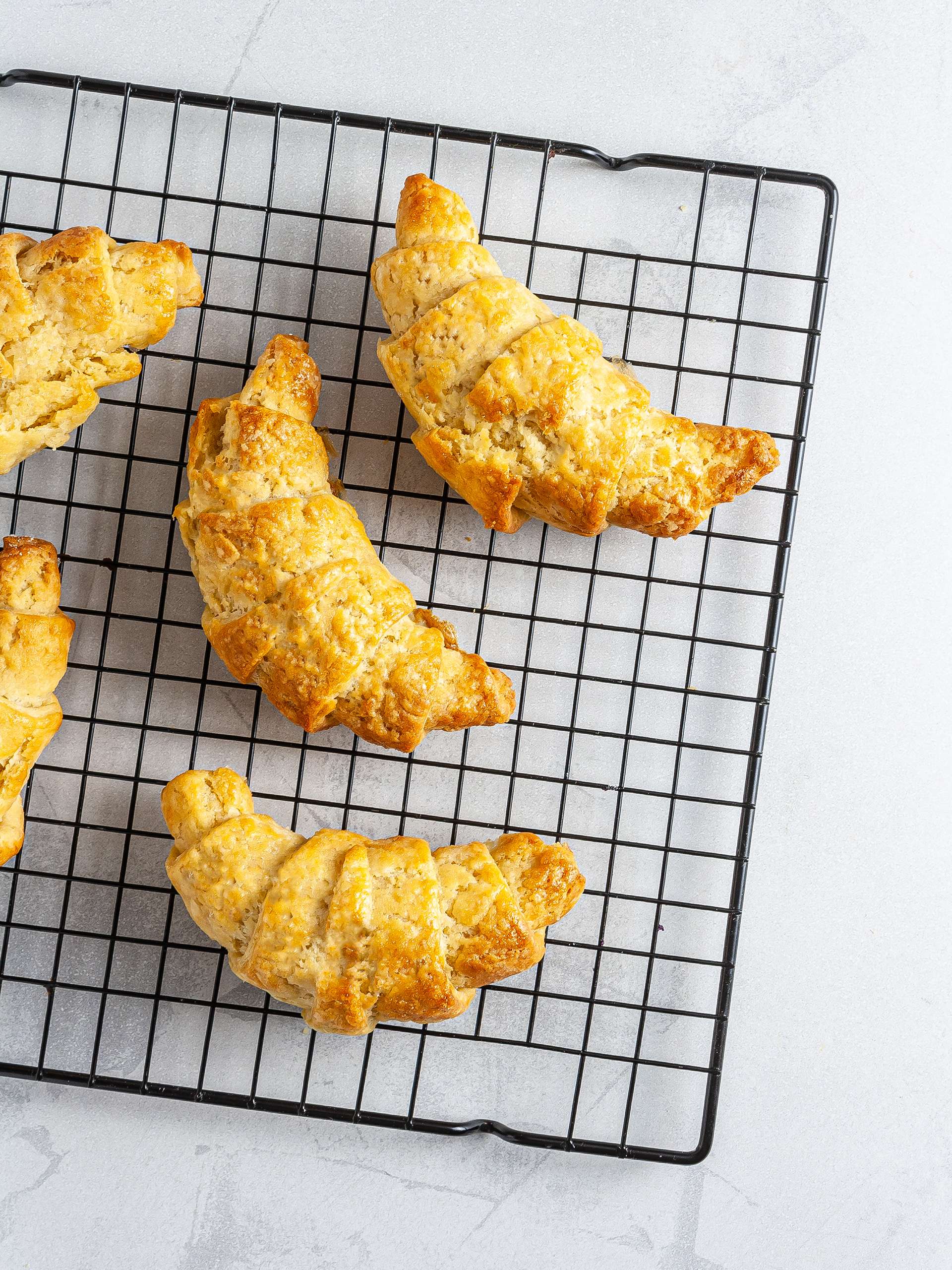 Baked croissants on a wire rack