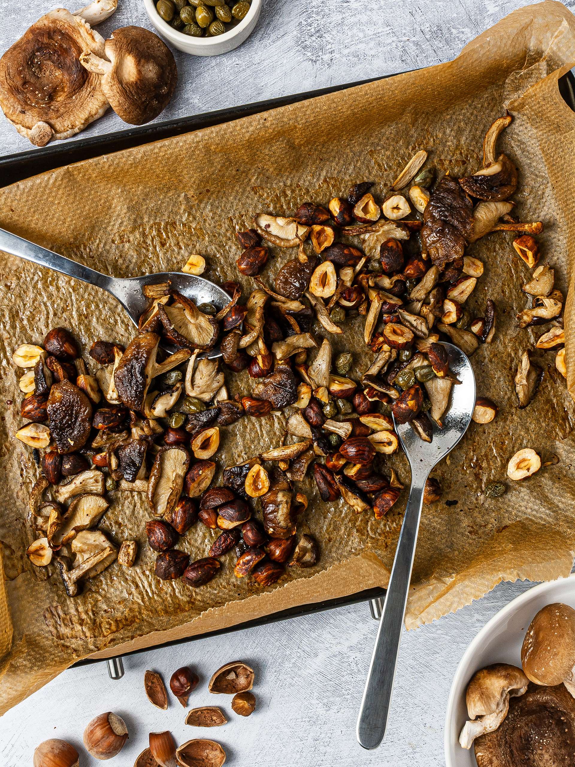 Roasted shiitake mushrooms with hazelnuts and capes over a baking tray