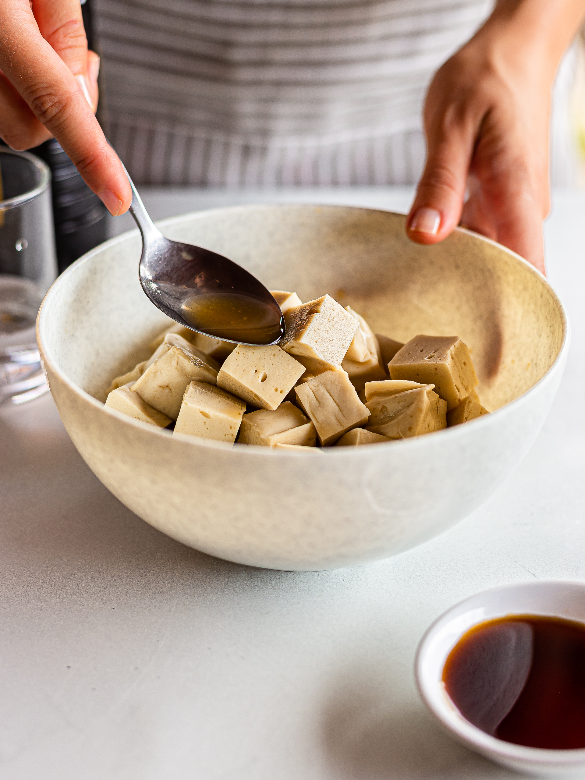 tofu cubes marinated in a bowl with soy sauce