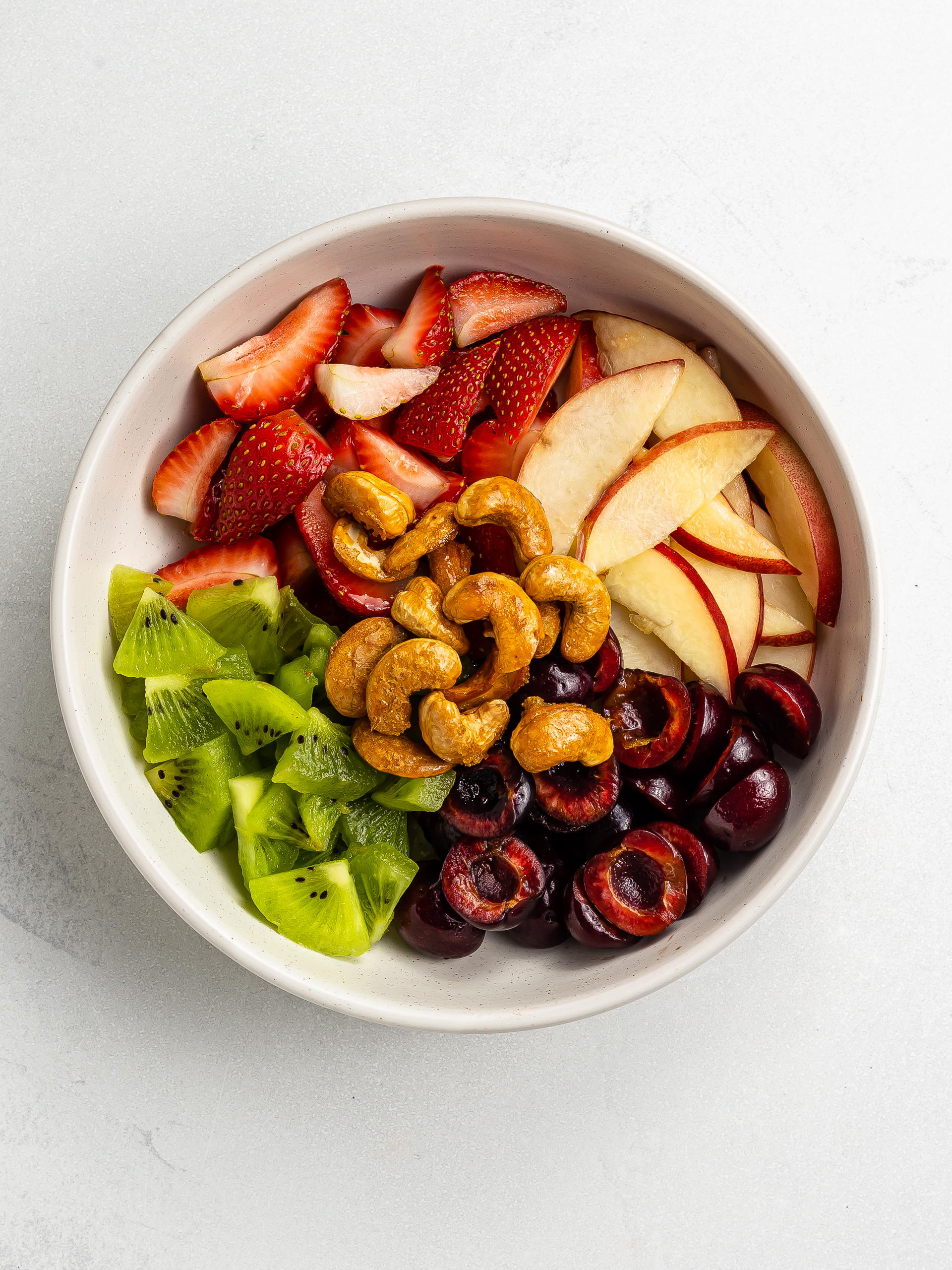 summer fruit salad bowl with caramelised cashews