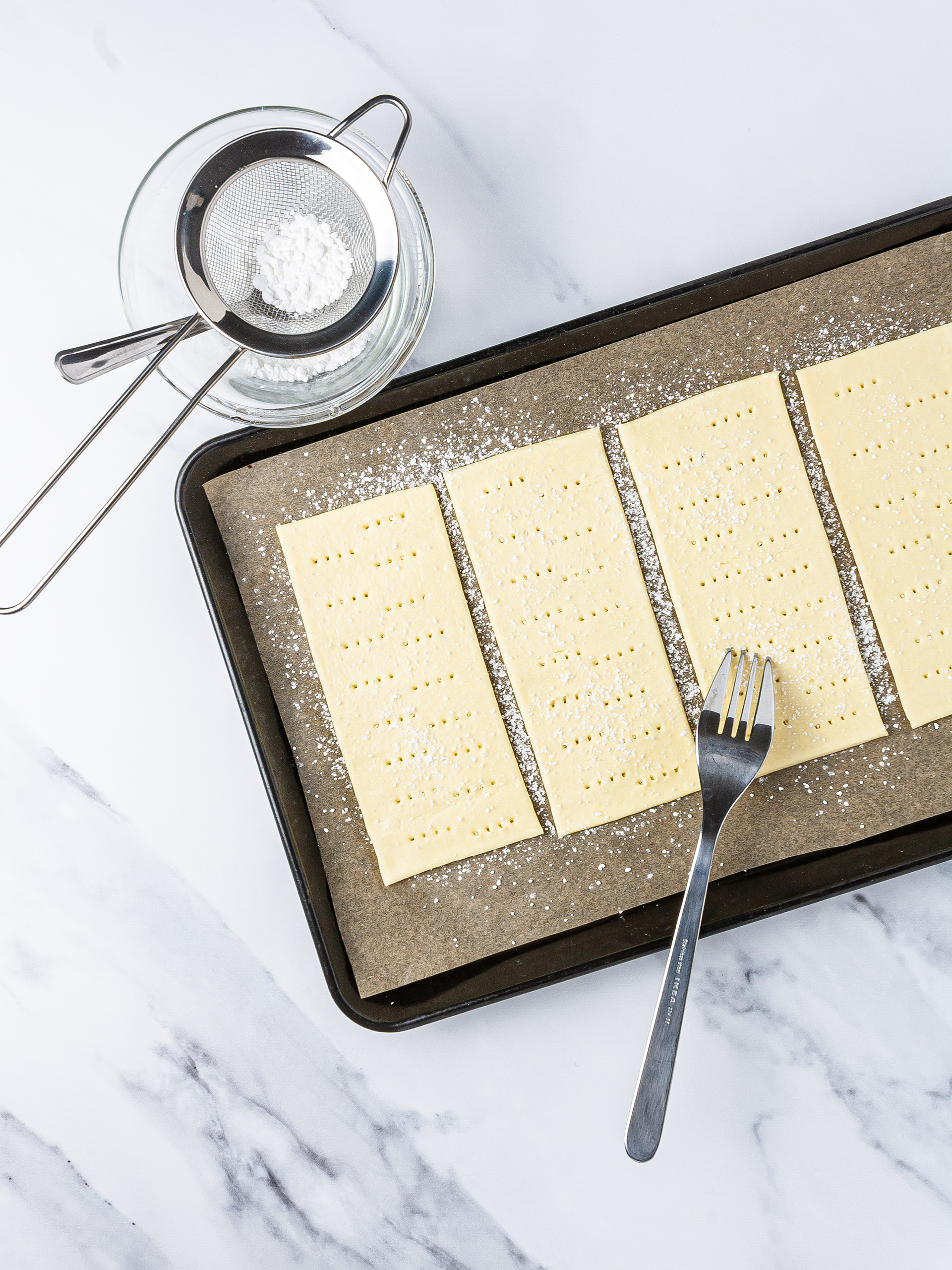 puff pastry sheet in a baking tray poked with a fork