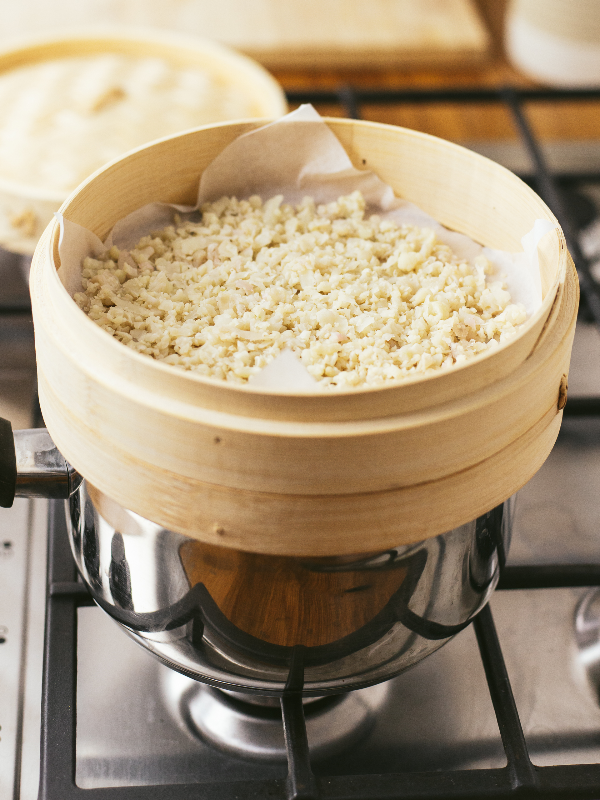 sticky cauliflower sushi rice cooking in a bamboo steamer