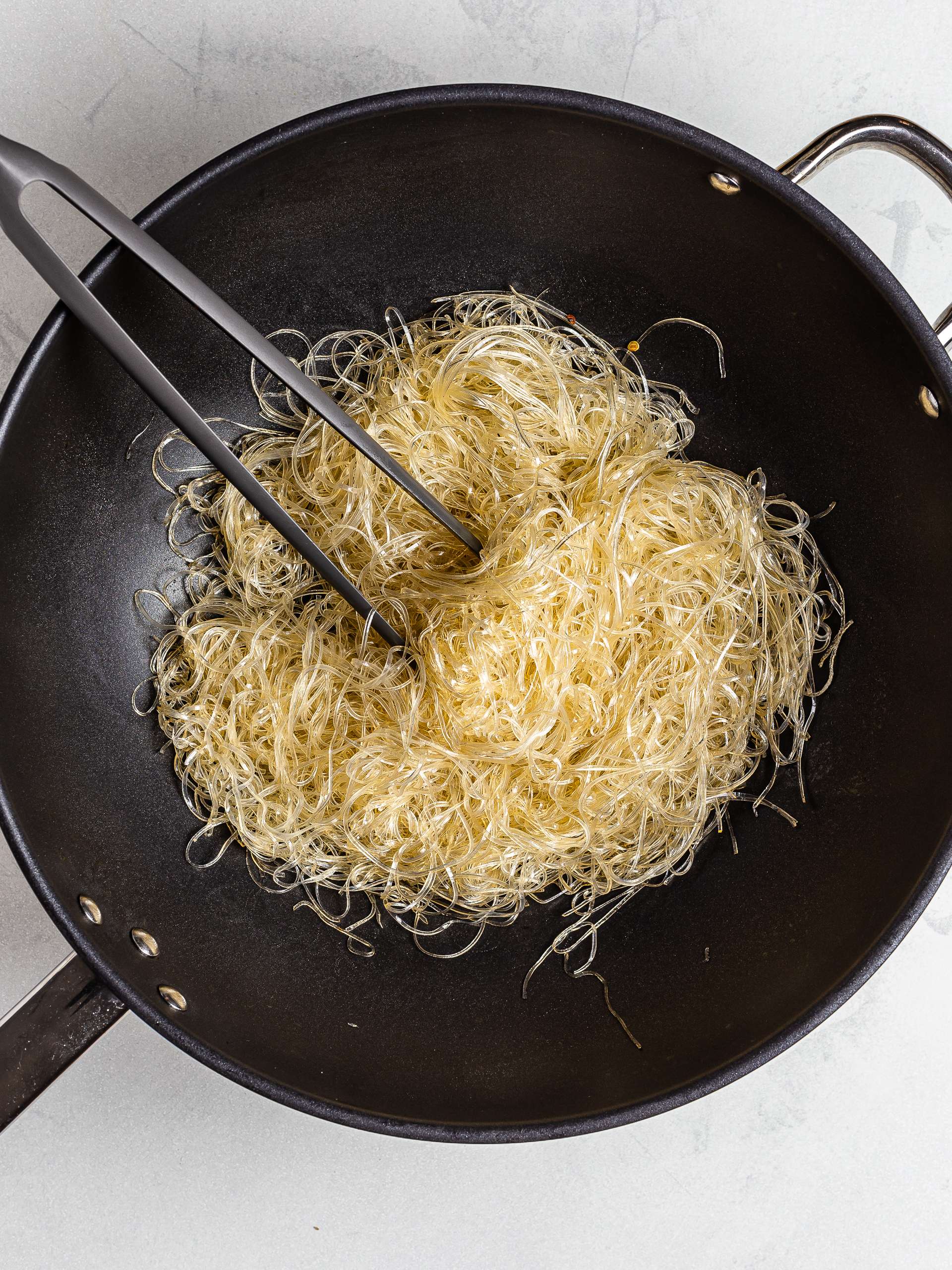 Glass noodles stir fried in a wok