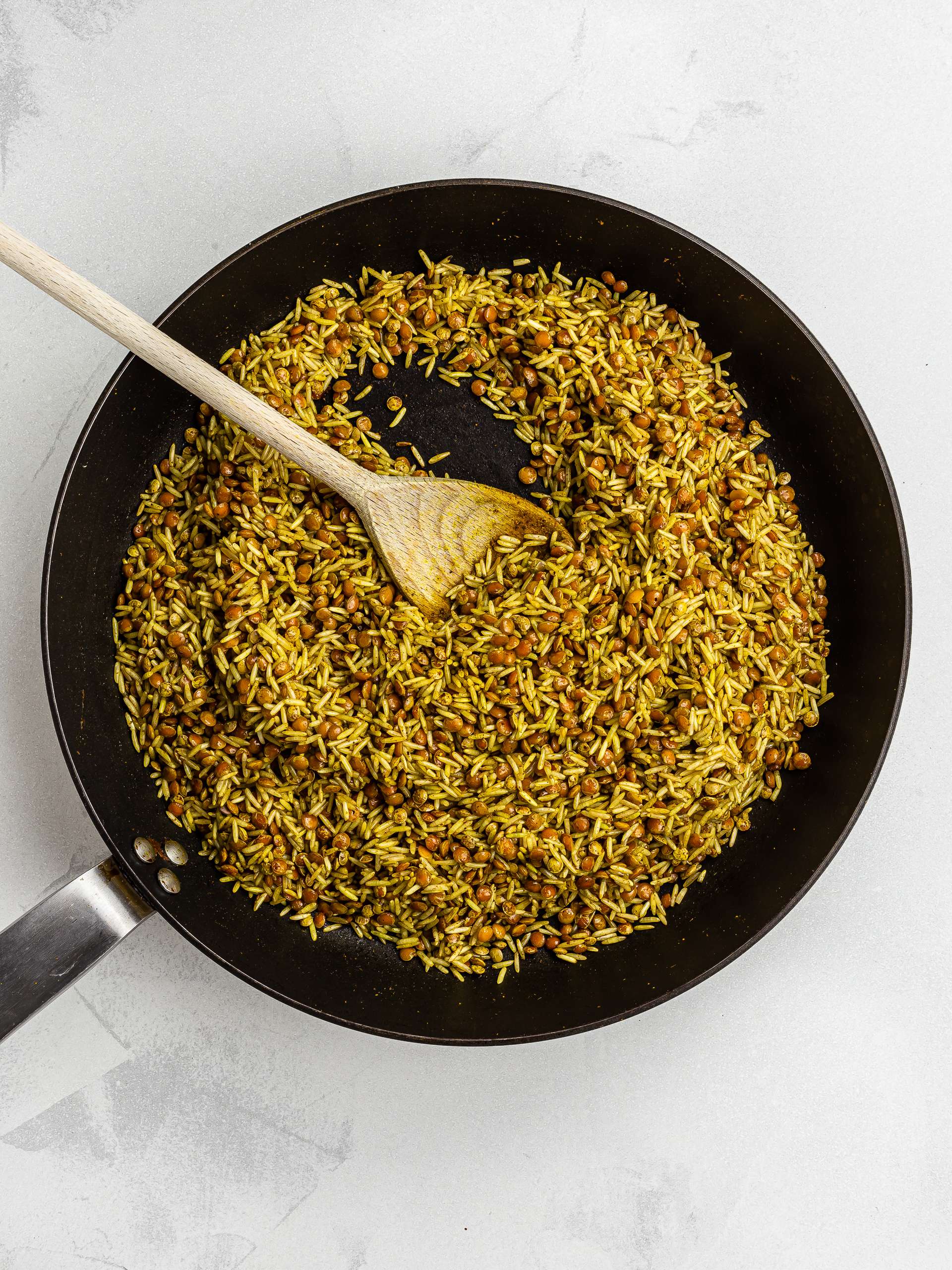 green lentils and brown rice in a skillet with lebanese spices