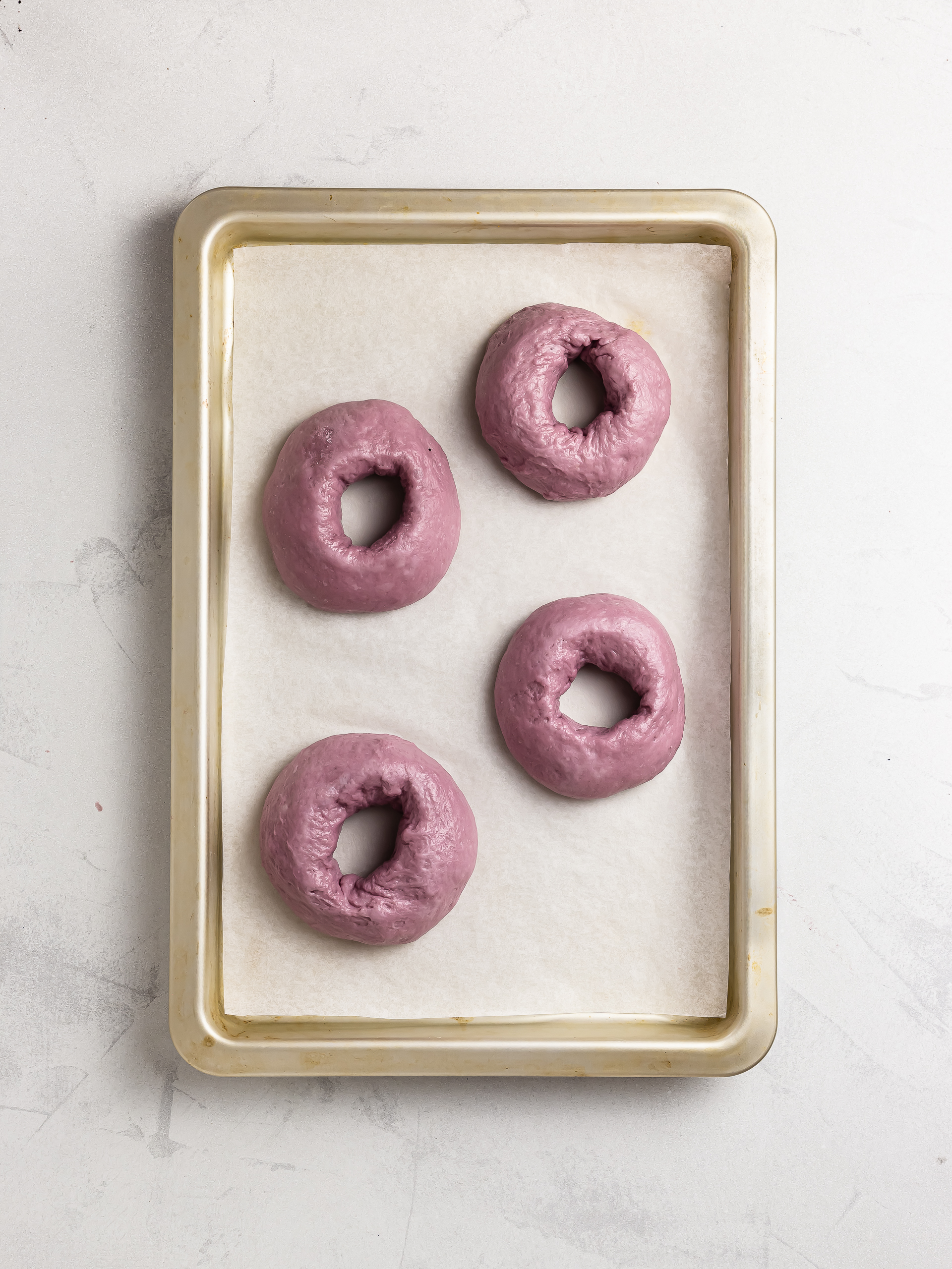 proved ube donuts on a tray