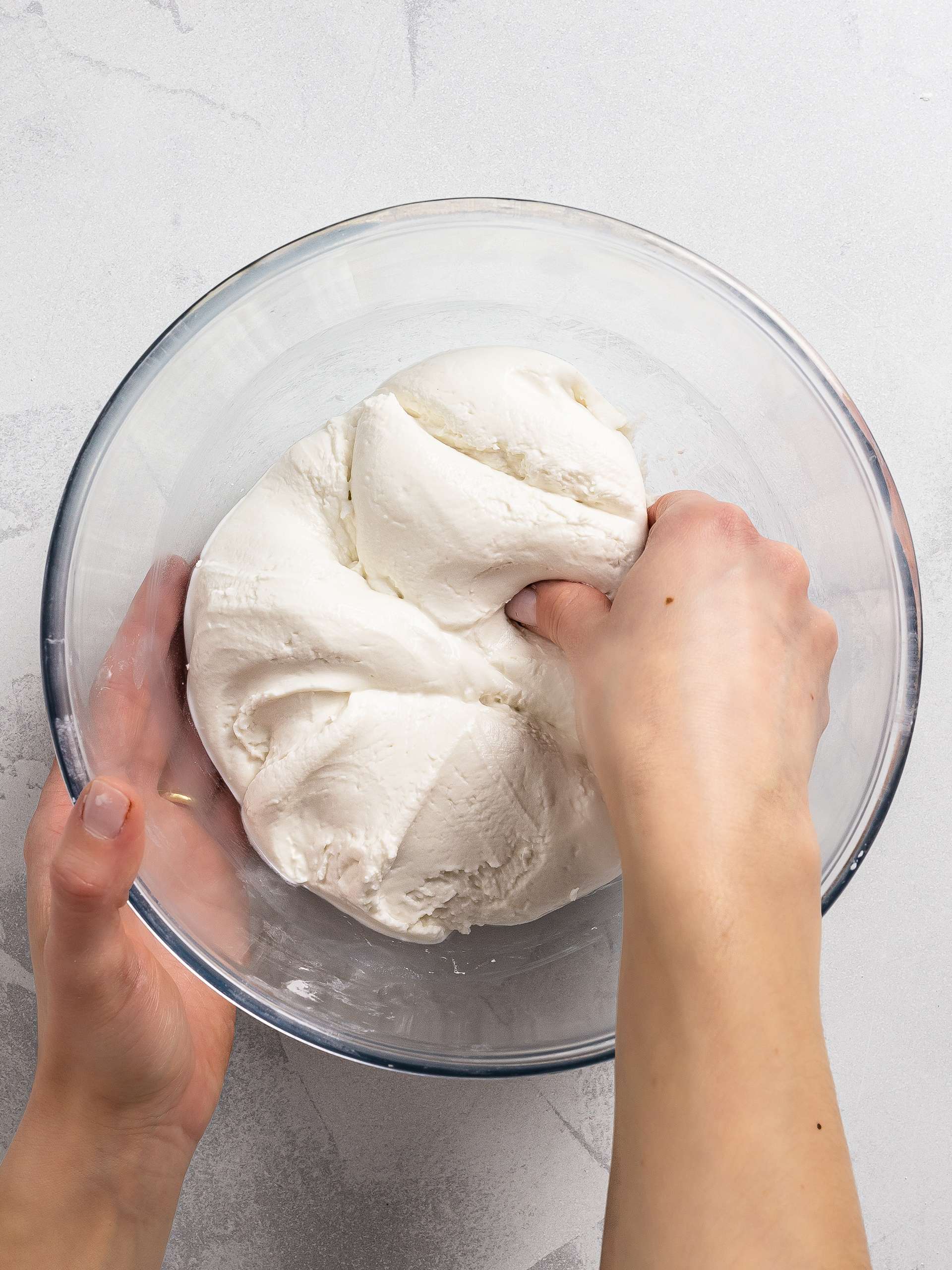 woman kneading mochi bread dough in a bowl
