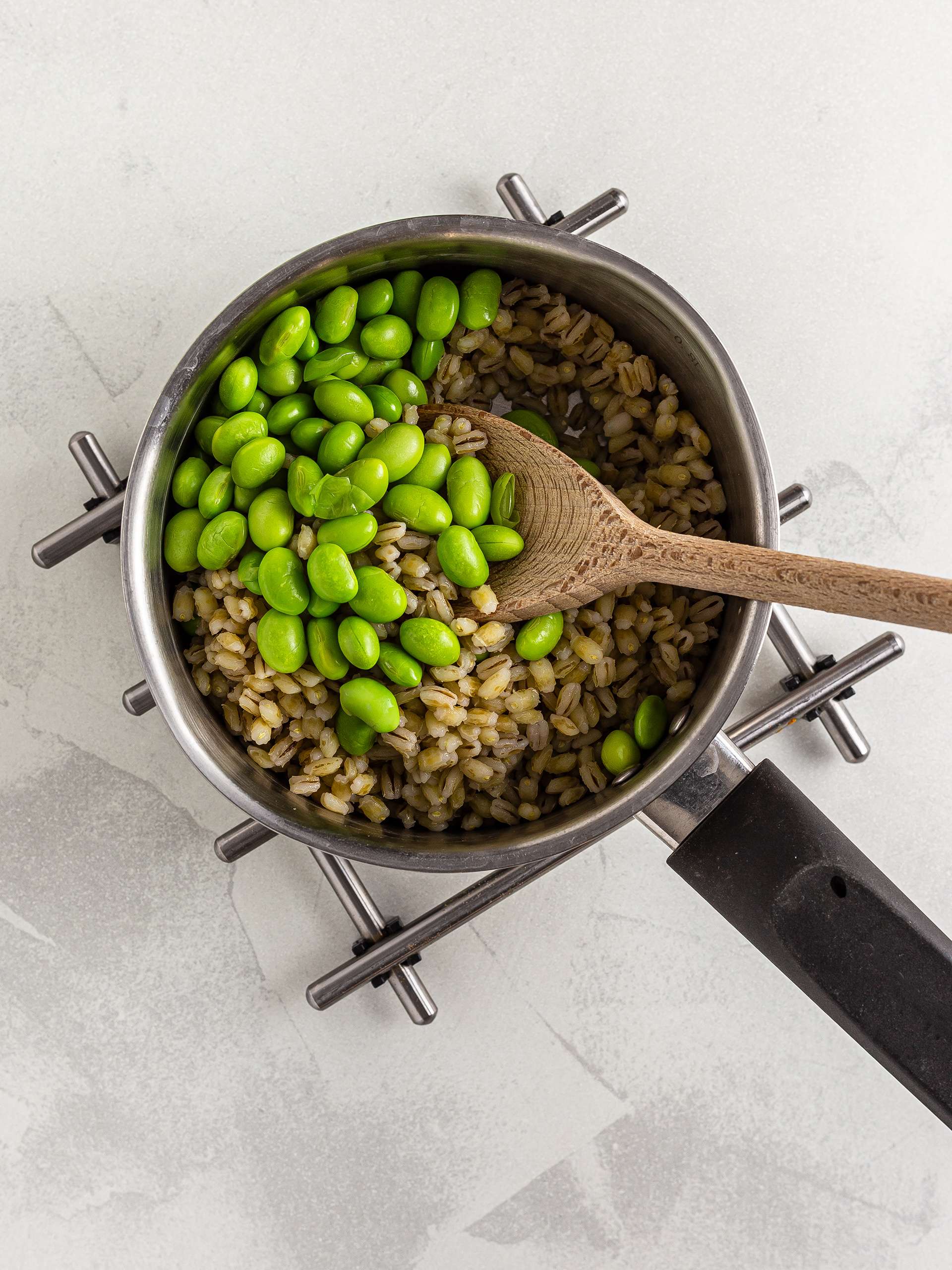 Cooked edamame beans with barley in a pot