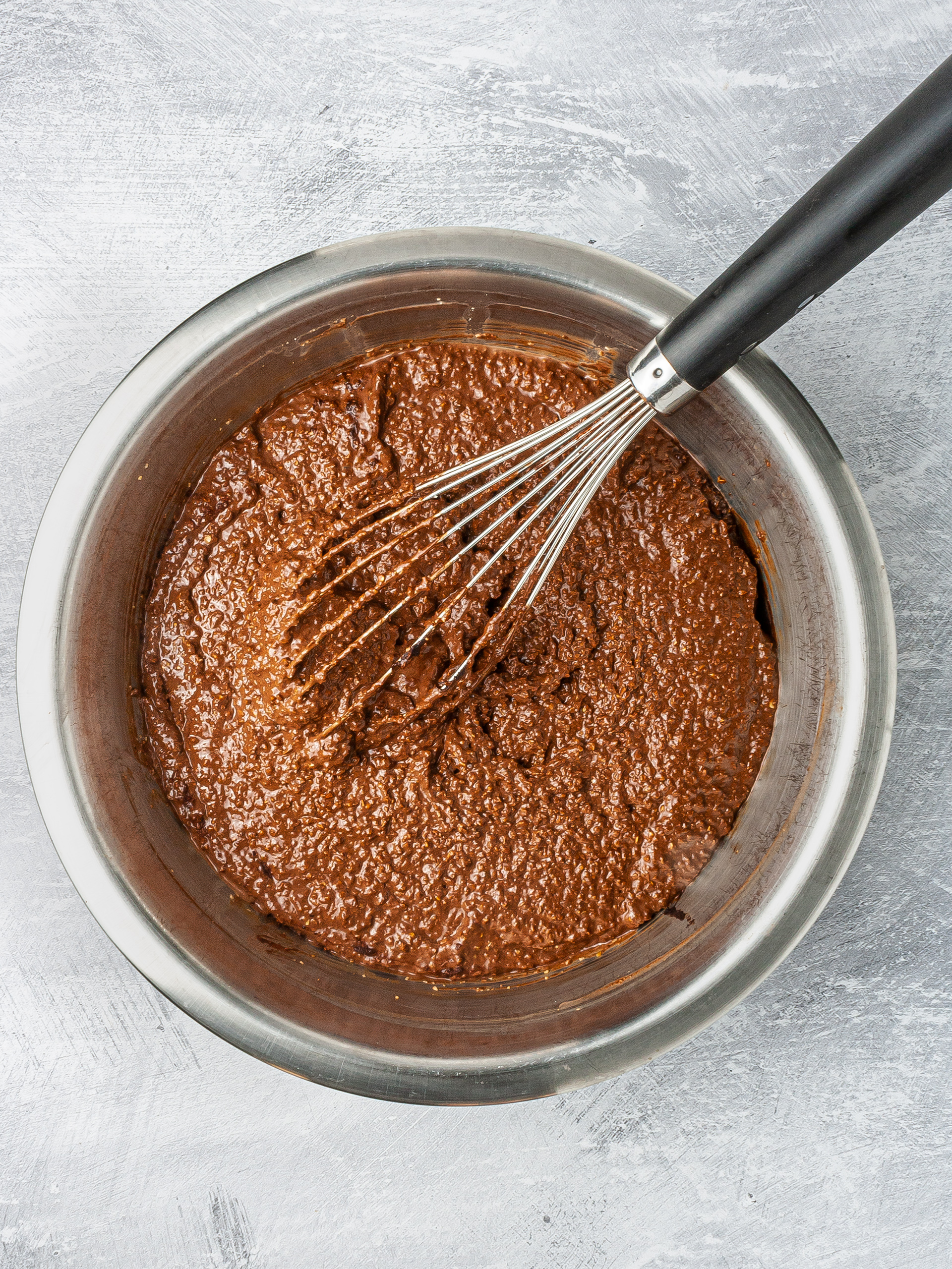 Chocolate lavender cake batter in a bowl with whisker.