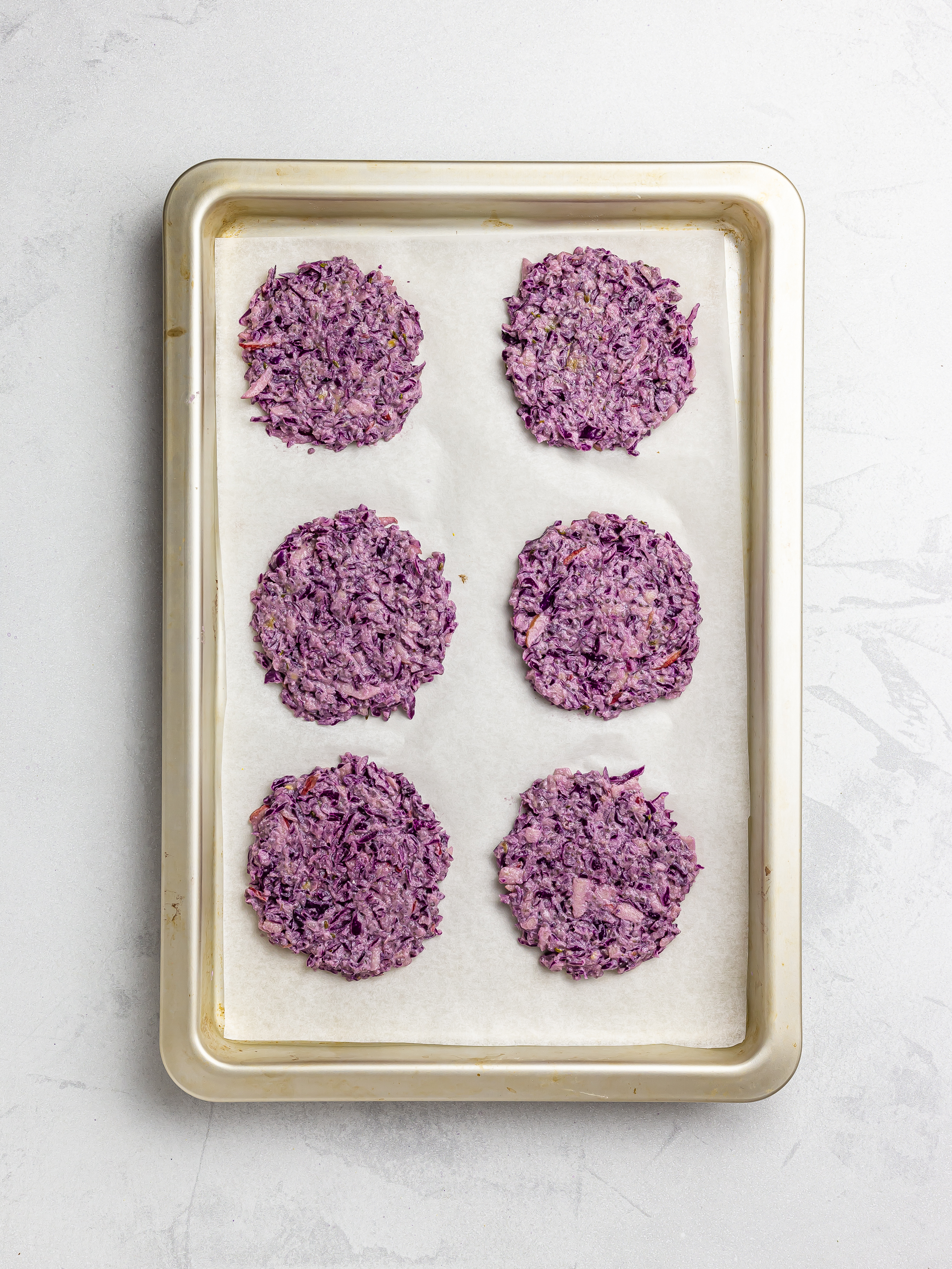 shaped red cabbage fritters on a baking tray