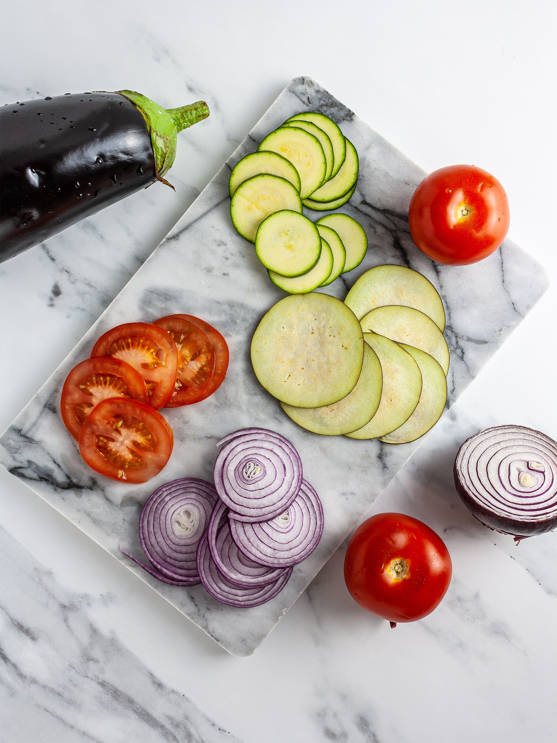 Sliced eggplants, zucchini, onions, and tomatoes