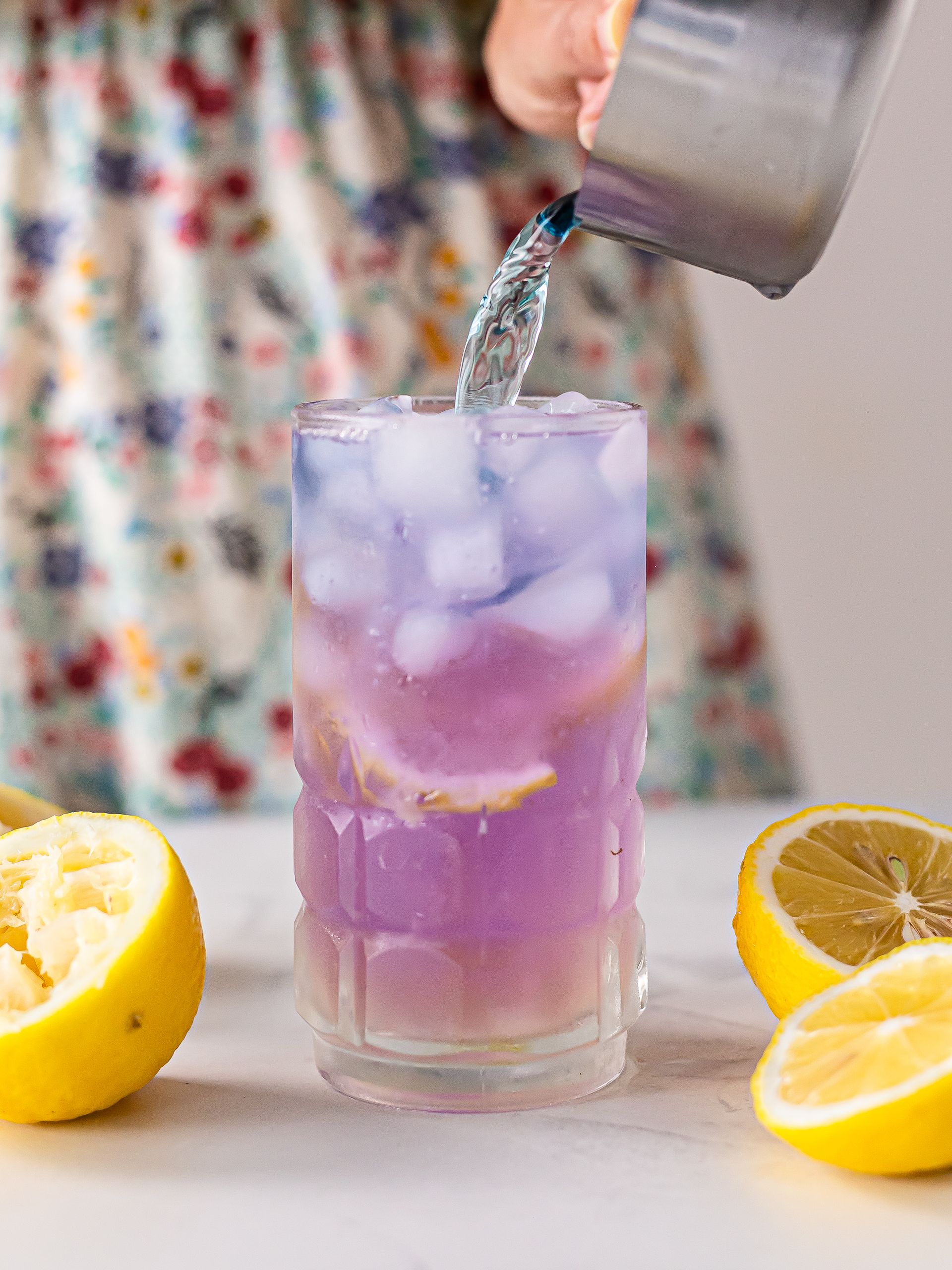 woman preparing butterfly pea lemonade with blue pea tea