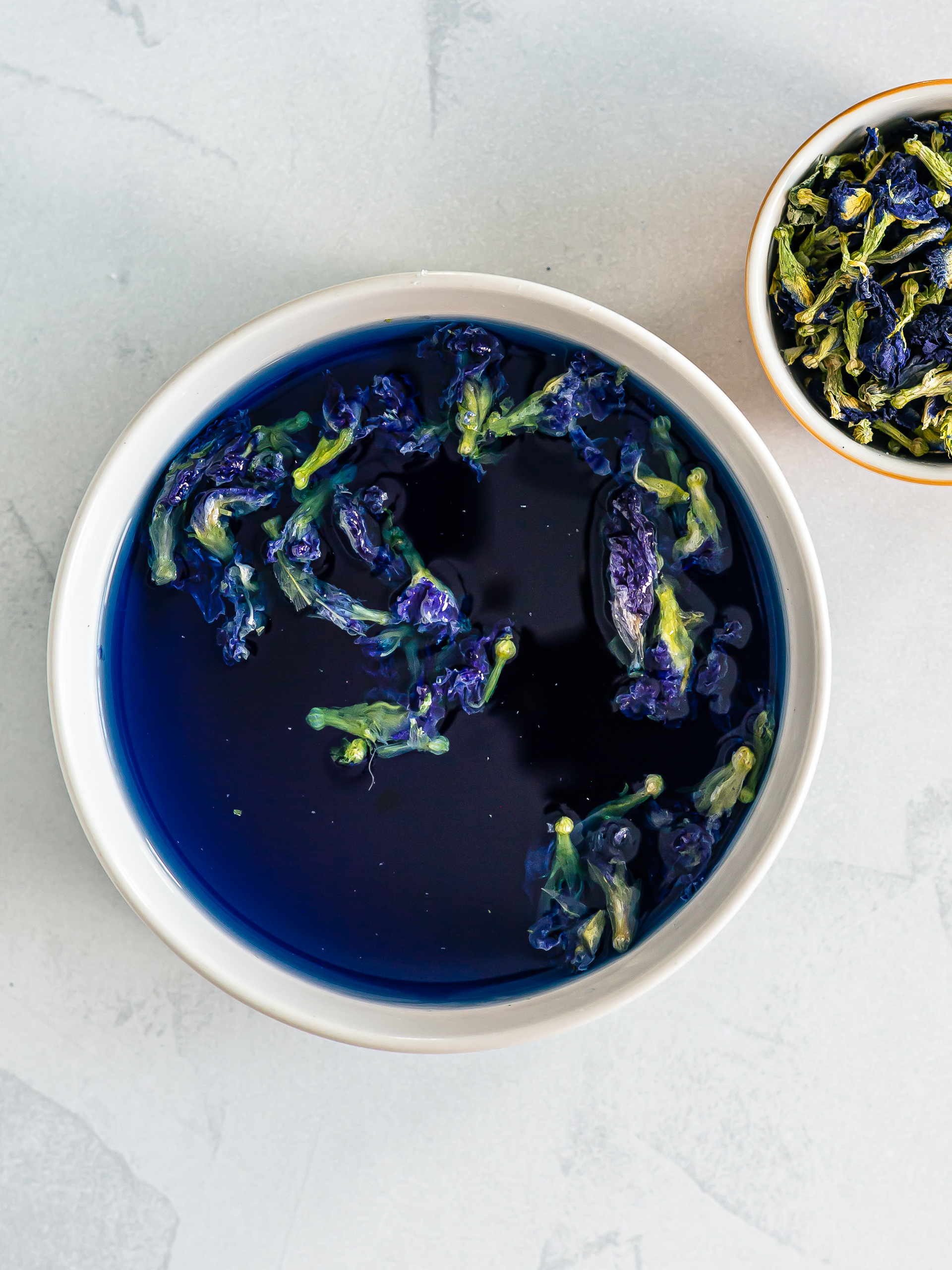 butterfly pea flowers steeping in water for blue tea