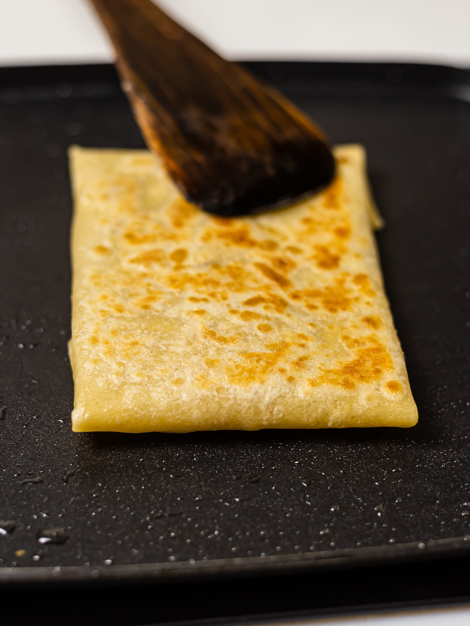 crispy thai banana pancake cooking in a skillet