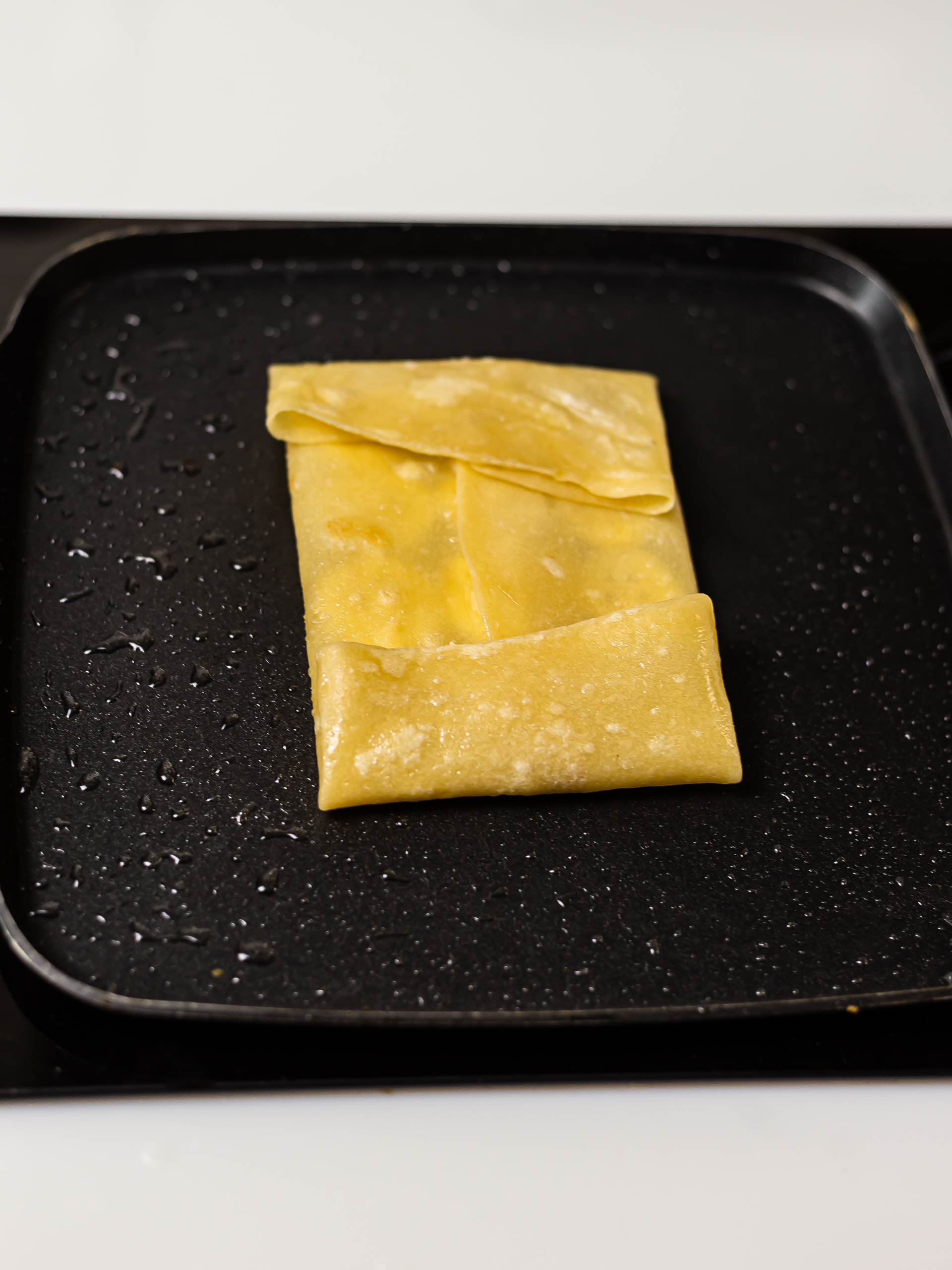 folded thai banana pancake cooking a skillet