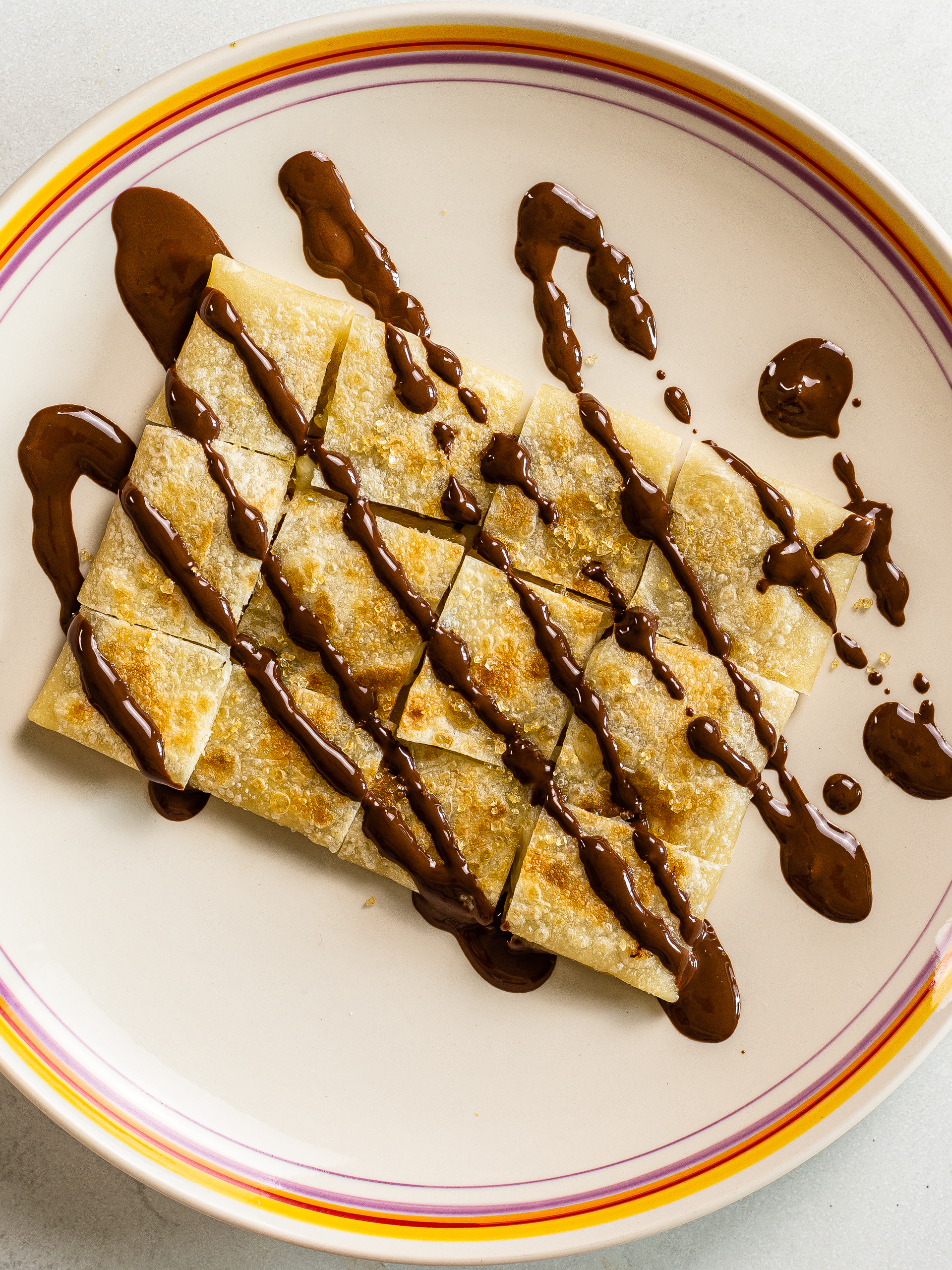 sliced thai banana pancake drizzled with melted chocolate