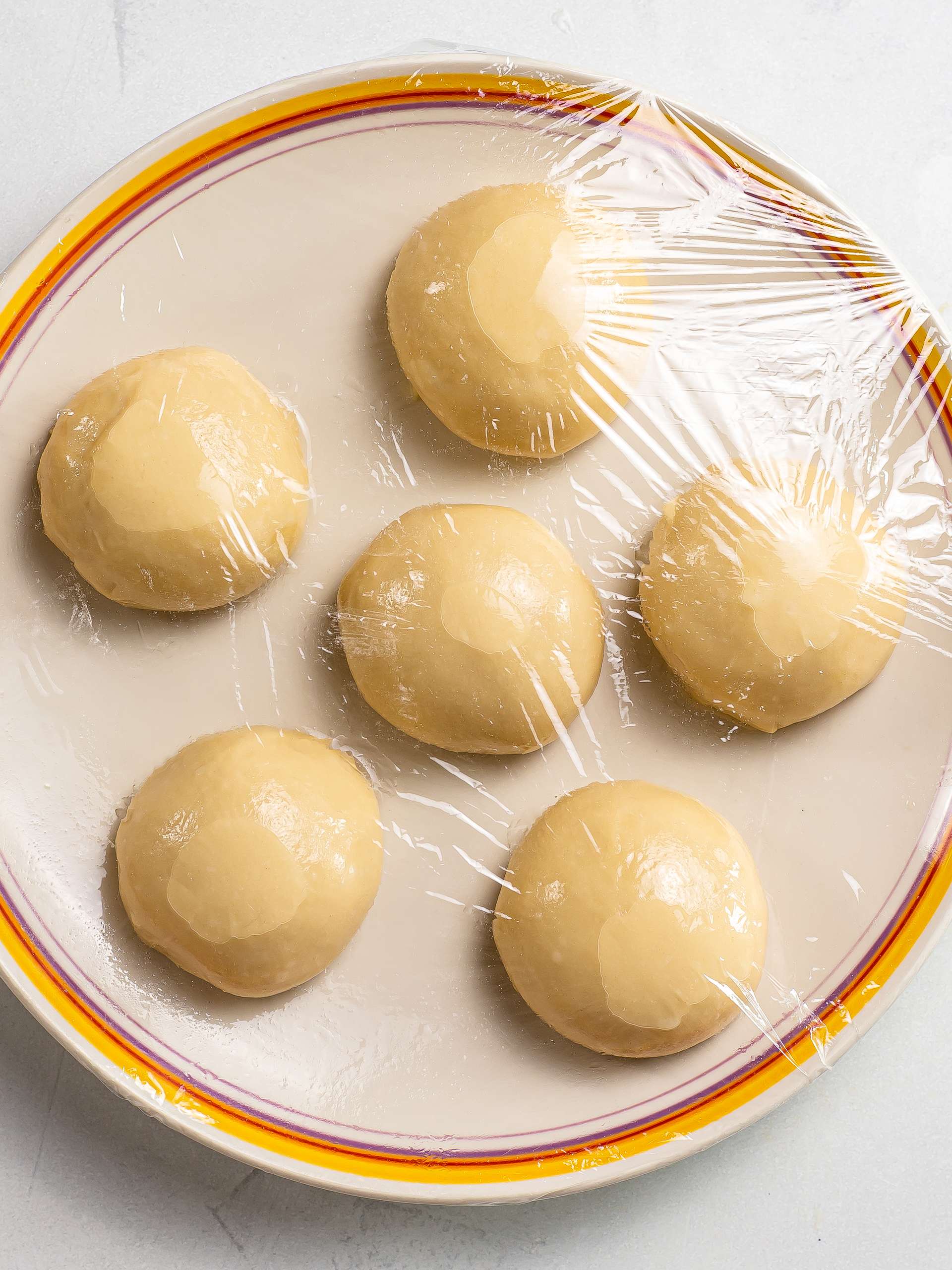 thai banana pancake dough balls resting on a plate