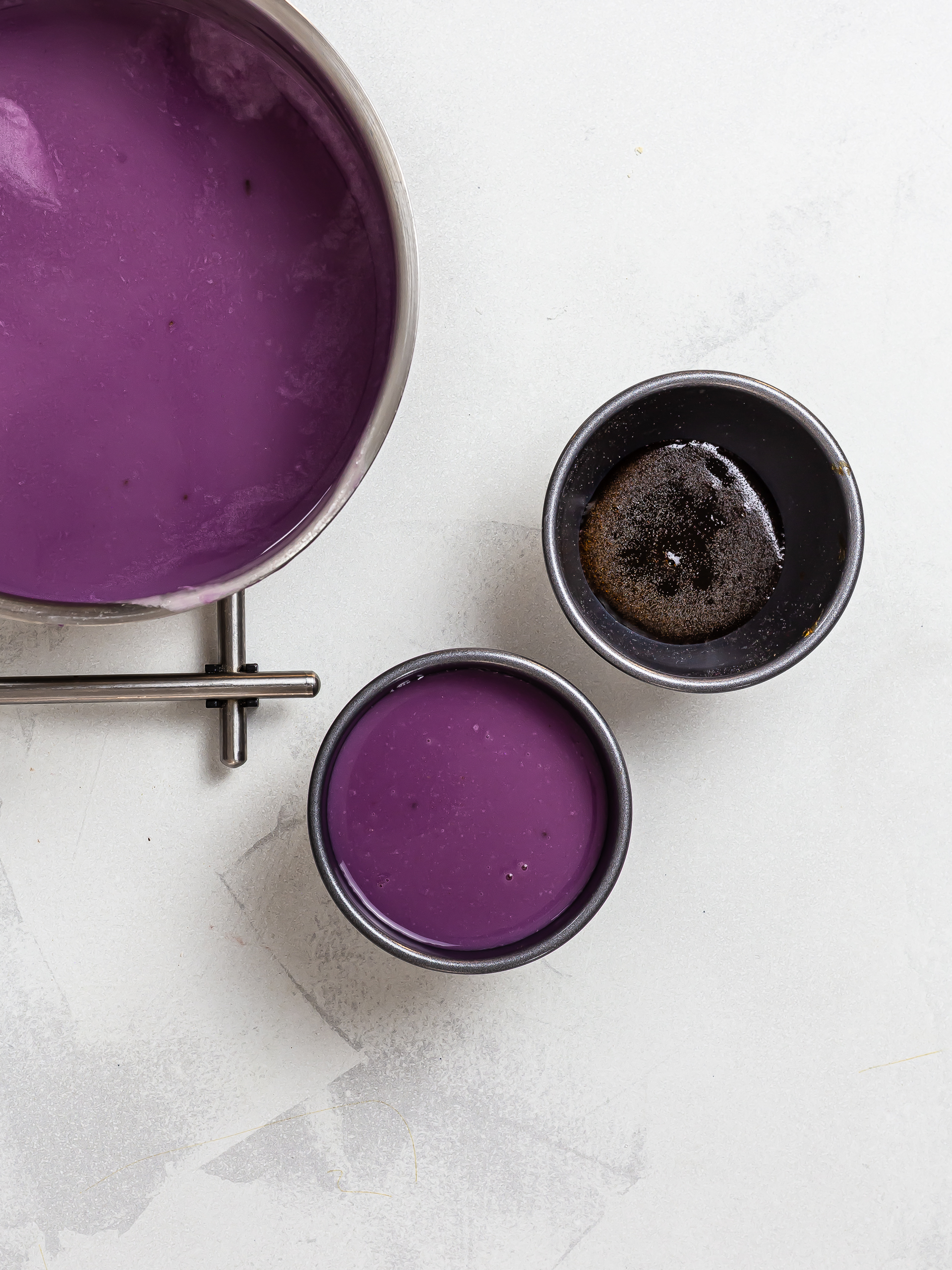 ube leche flan poured into tin with caramel base layer