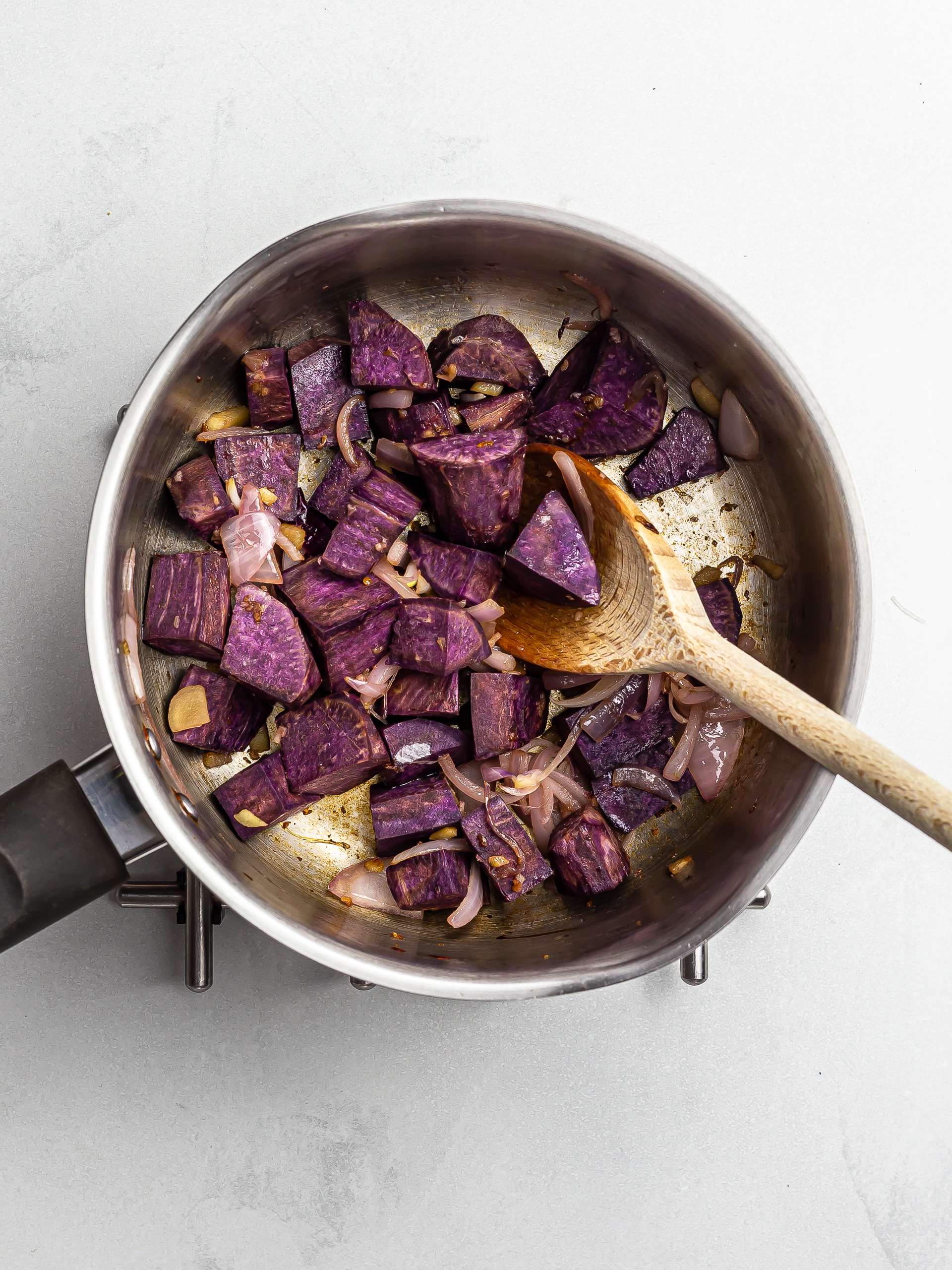 purple yam onions and ginger cooking in a pot
