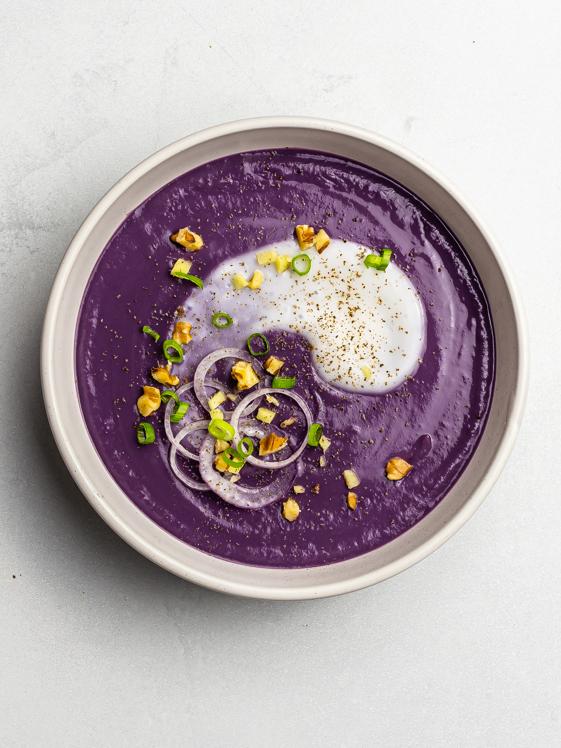 purple yam ube soup in a bowl with coconut milk
