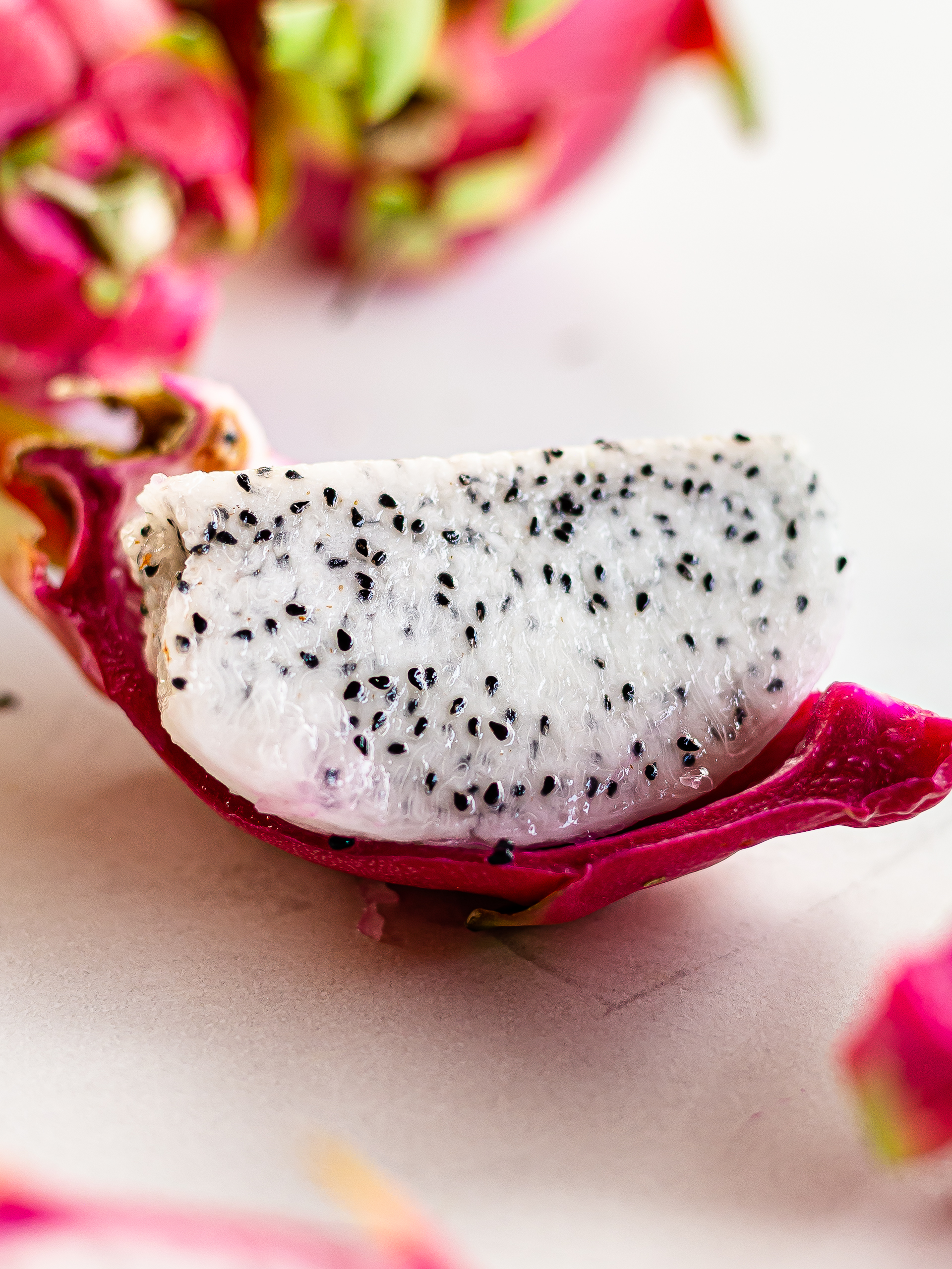 segment of dragon fruit pulp on pink peel