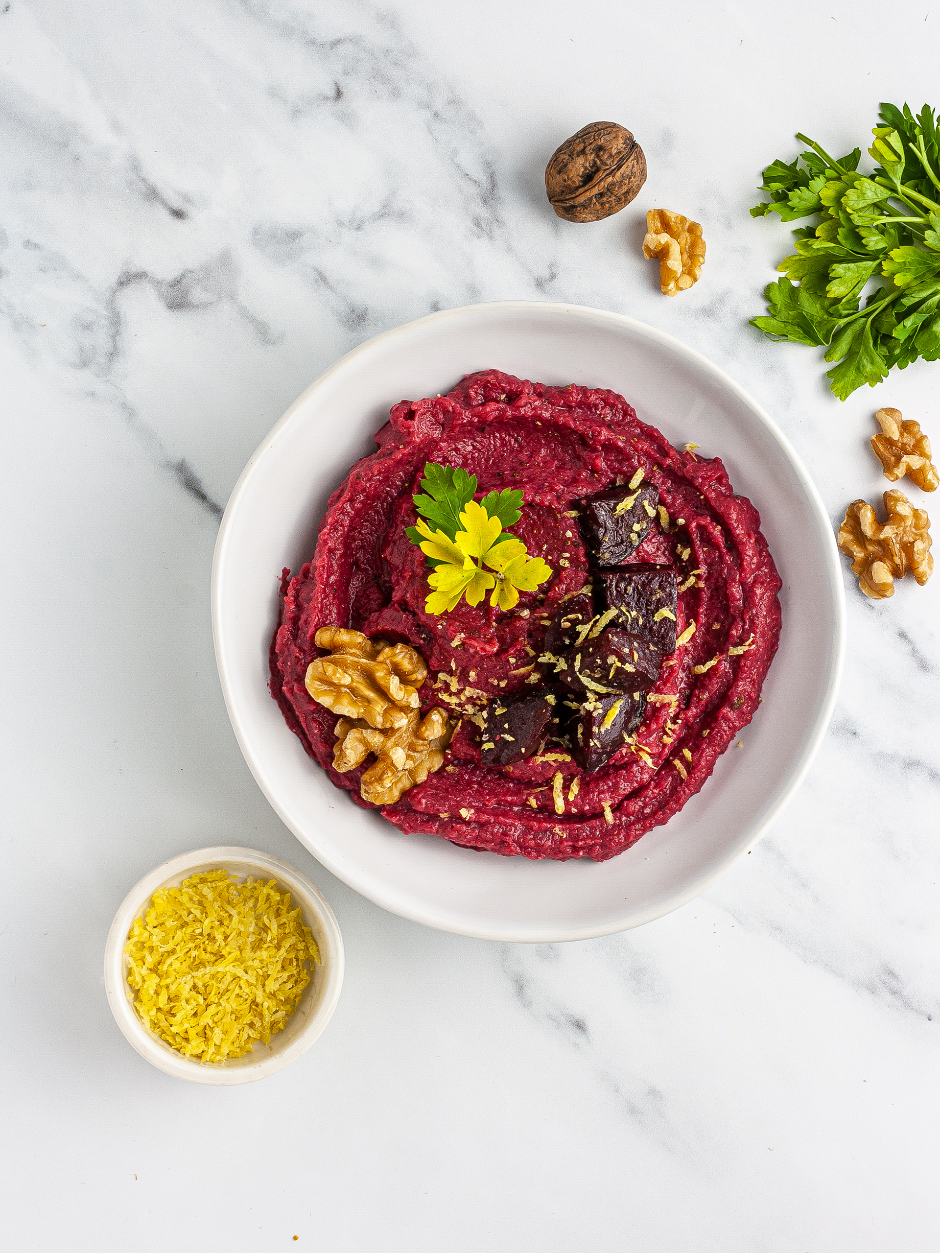 Hummus garnished with walnuts and lemon zest.