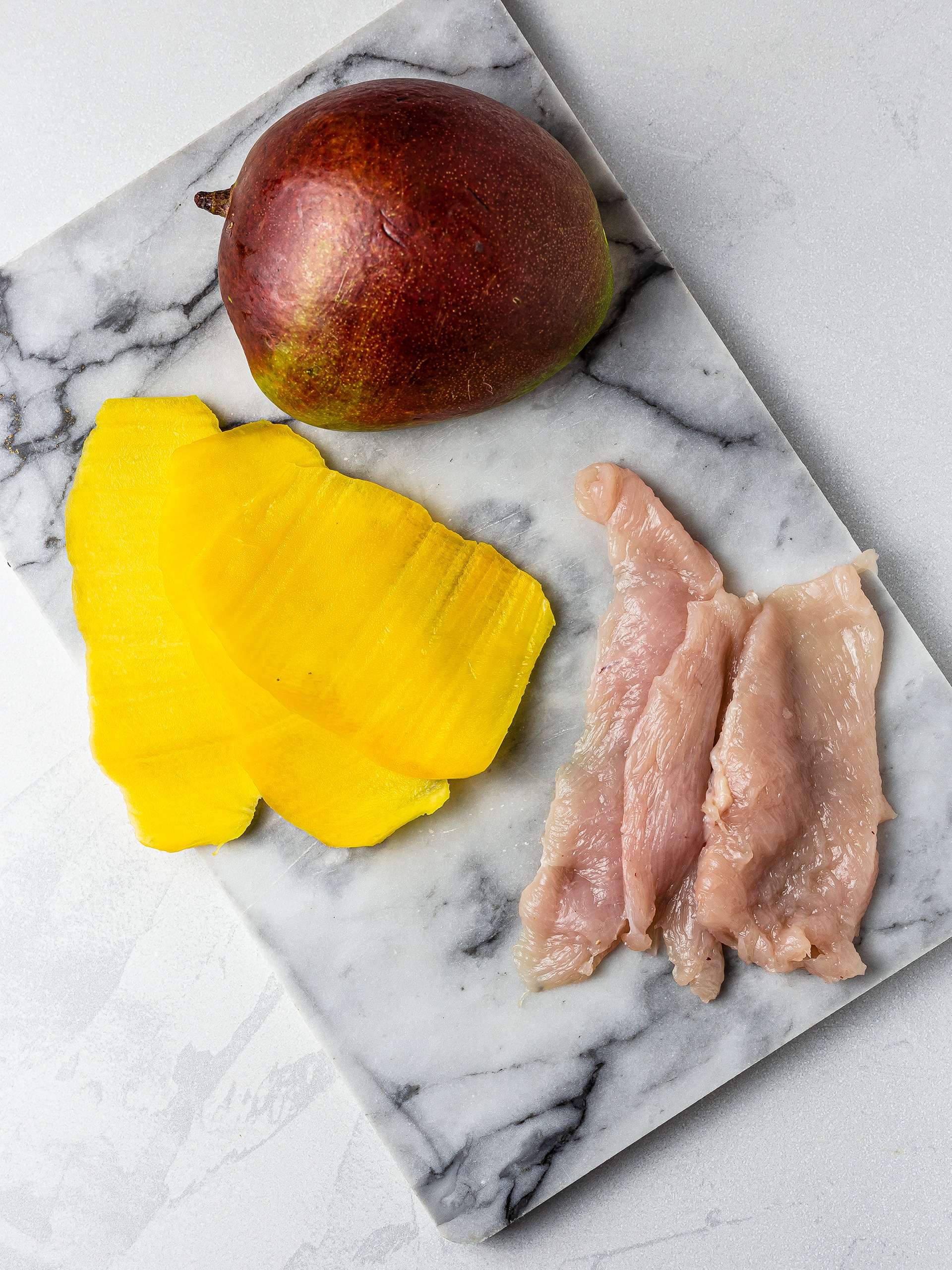 Sliced mango and chicken breast