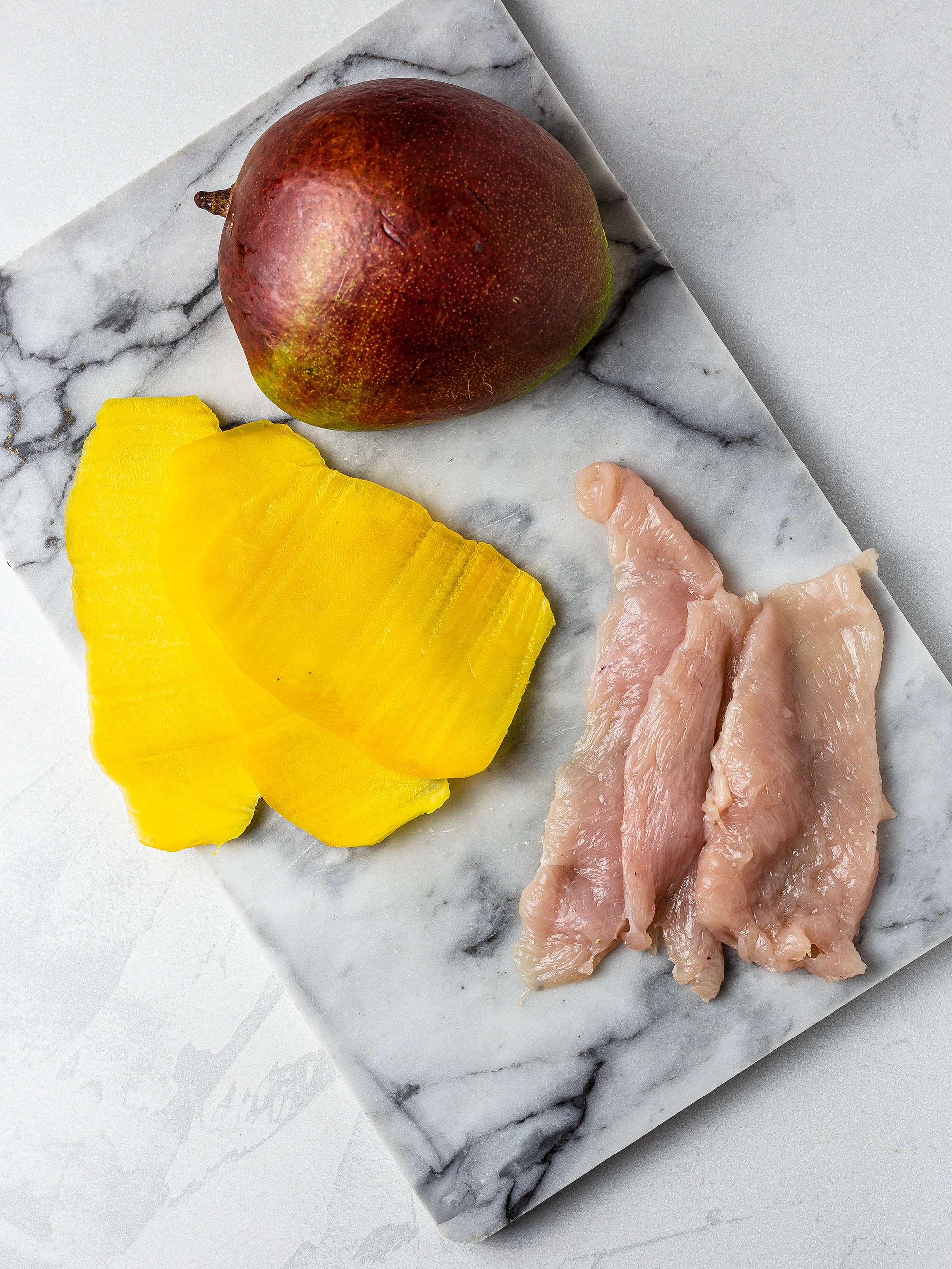 Sliced mango and chicken breast