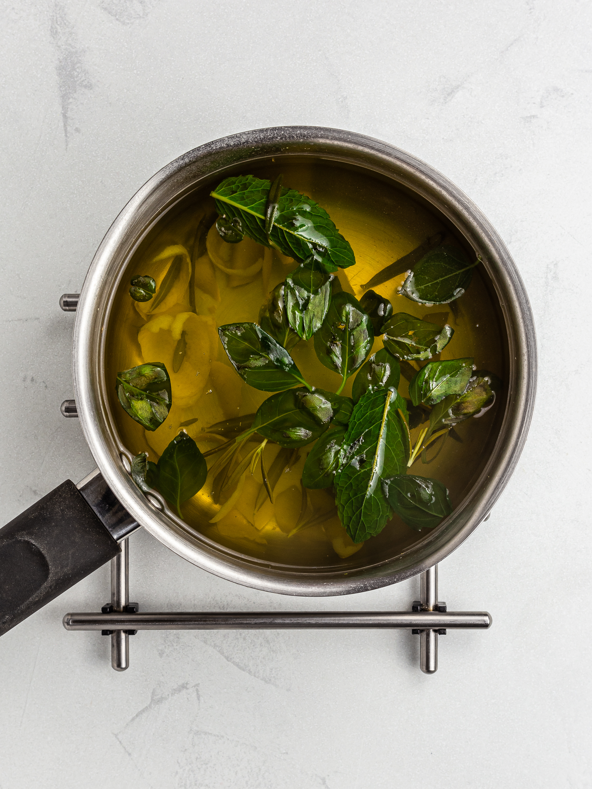 fresh herbs infusing in a pot of hot water